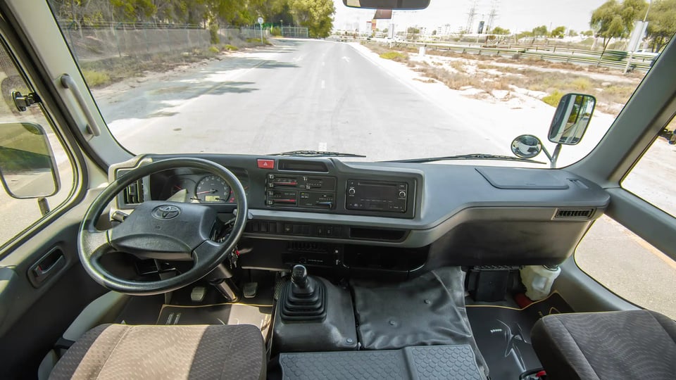 Used 2020 Toyota Coaster Bus in White – Front Cabin / Dashboard Full View for Sale at First Choice Cars Dubai Sharjah