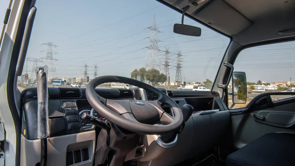Used 2024 Mitsubishi Canter Tipper in White – Driver Side Dashboard & Steering View for Sale at First Choice Cars Dubai Sharjah