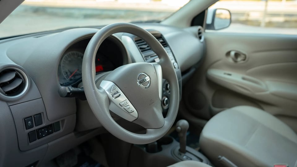 Used 2022 Nissan Sunny SV in White – Driver Side Dashboard & Steering View for Sale at First Choice Cars Dubai Sharjah