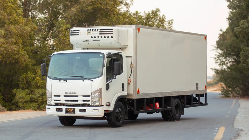 Used 2016 Isuzu NPR Freezer Box in White – Left Front Diagonal (45°) View for Sale at First Choice Cars Dubai Sharjah