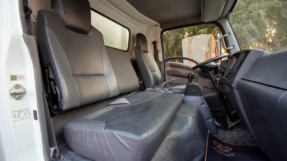 Used 2016 Isuzu NPR Freezer Box in White – Front Passenger Side Cabin View for Sale at First Choice Cars Dubai Sharjah