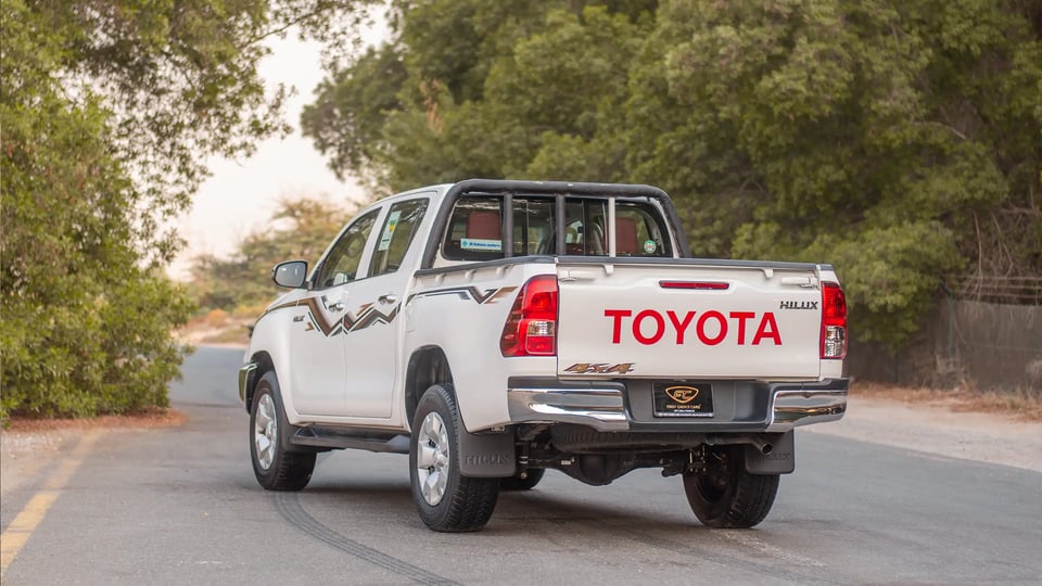 Used 2024 Toyota Hilux DLX Double Cabin in White – Left Back Diagonal (45°) View for Sale at First Choice Cars Dubai Sharjah