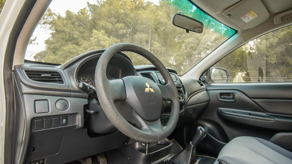 Used 2021 Mitsubishi L200 GL Double Cabin in White – Driver Side Dashboard & Steering View for Sale at First Choice Cars Dubai Sharjah