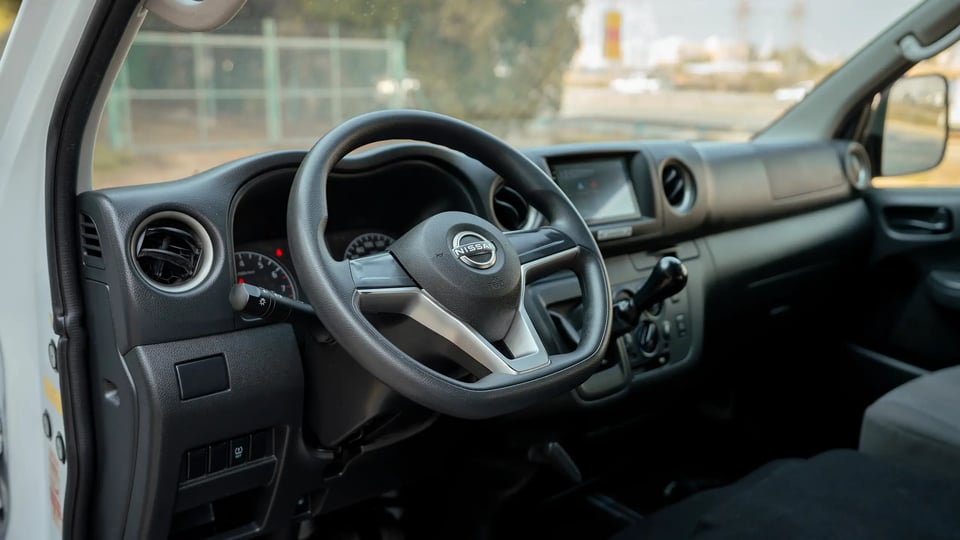 Used 2024 Nissan Urvan High Roof in White – Driver Side Dashboard & Steering View for Sale at First Choice Cars Dubai Sharjah