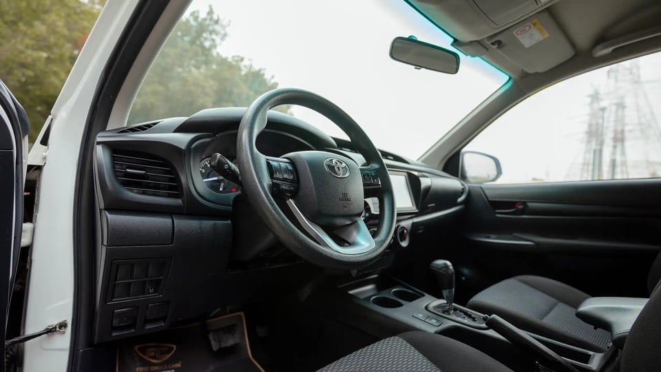 Used 2021 Toyota Hilux GLX Double Cabin in White – Driver Side Dashboard & Steering View for Sale at First Choice Cars Dubai Sharjah