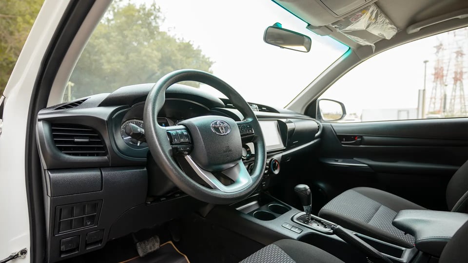 Used 2024 Toyota Hilux GL Double Cabin in White – Driver Side Dashboard & Steering View for Sale at First Choice Cars Dubai Sharjah