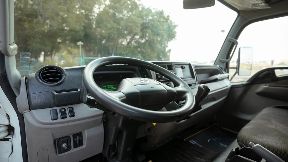Used 2023 Mitsubishi Canter Chiller Box in White – Driver Side Dashboard & Steering View for Sale at First Choice Cars Dubai Sharjah