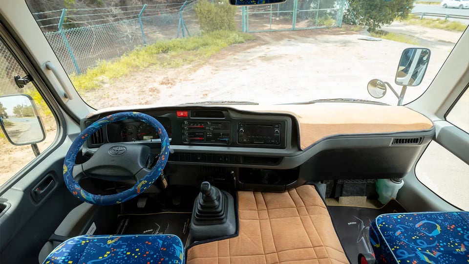 Used 2022 Toyota Coaster High Roof in White – Front Cabin / Dashboard Full View for Sale at First Choice Cars Dubai Sharjah