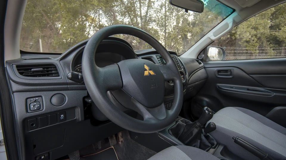Used 2020 Mitsubishi L200 GLX Double Cabin in White – Driver Side Dashboard & Steering View for Sale at First Choice Cars Dubai Sharjah