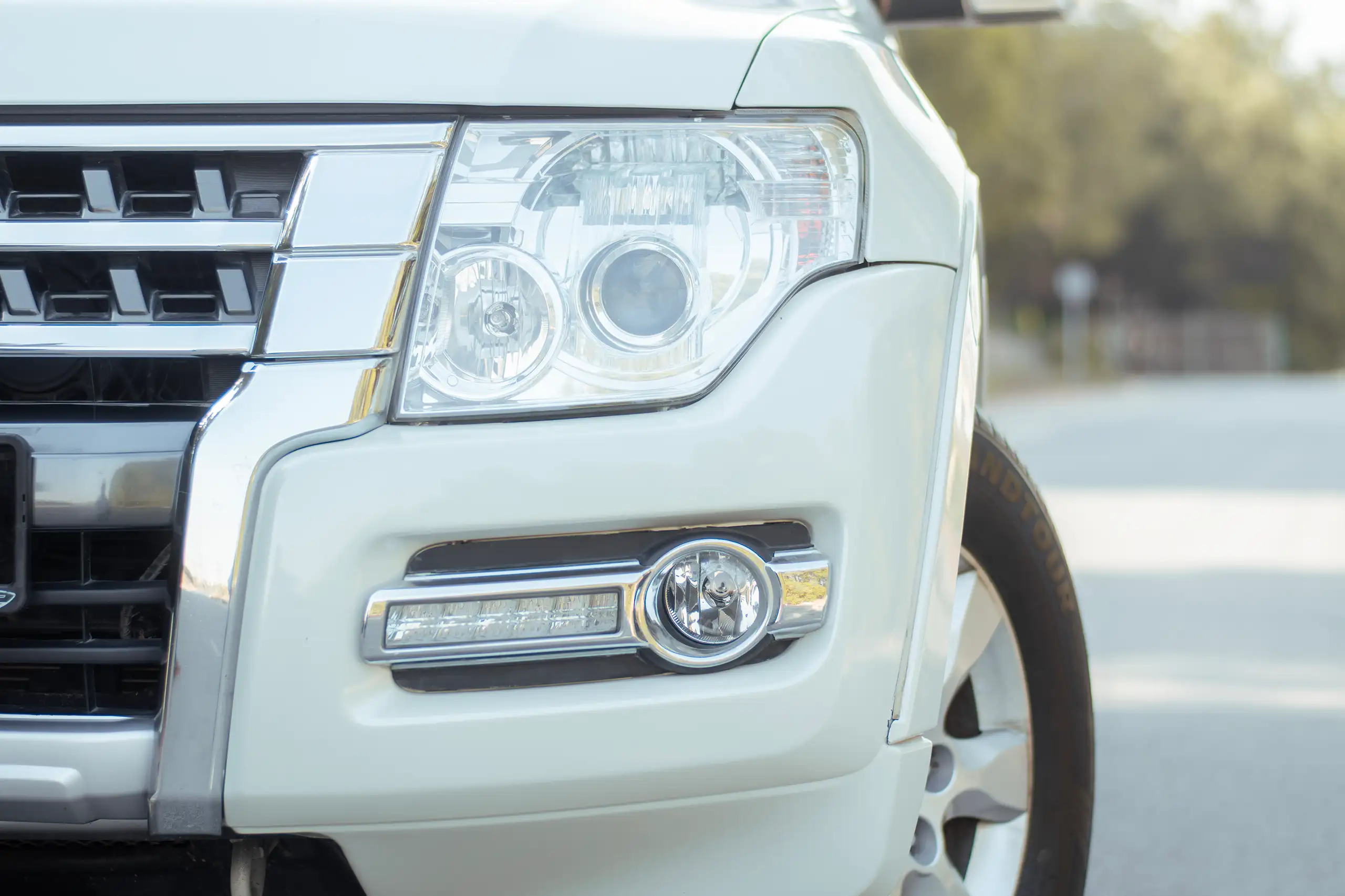 Used 2022 Mitsubishi Pajero GLS White – Headlight Close-up at First Choice Cars Sharjah