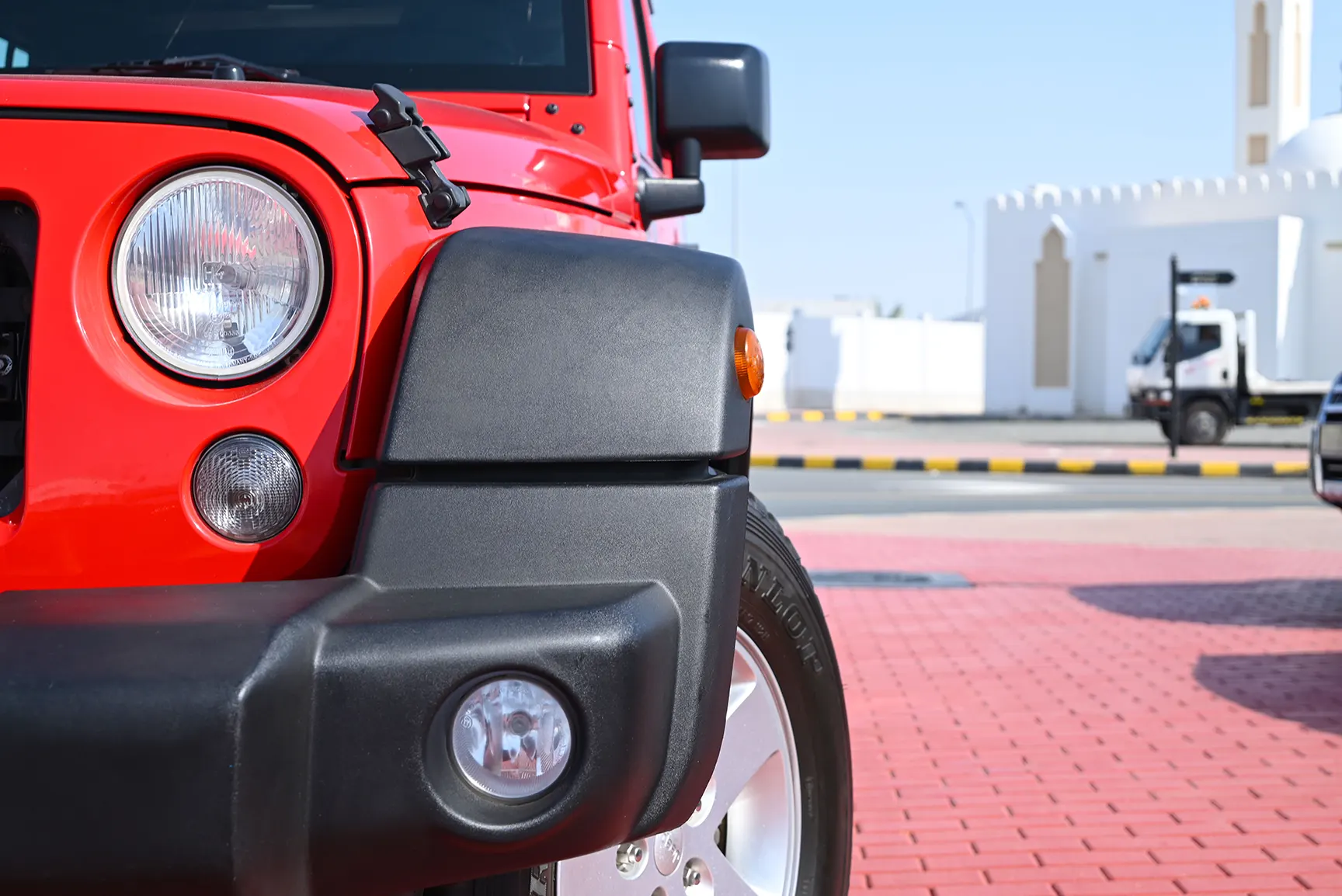 Used 2016 Jeep Wrangler Unlimited Sport Red – Headlight Close-up at First Choice Cars Sharjah