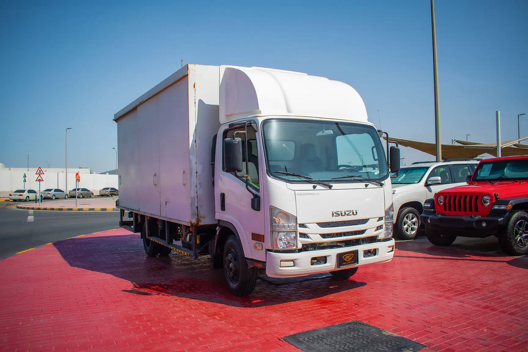 Used 2019 Isuzu NPR Cargo Box in White – Right Front Diagonal (45°) View for Sale at First Choice Cars Dubai Sharjah