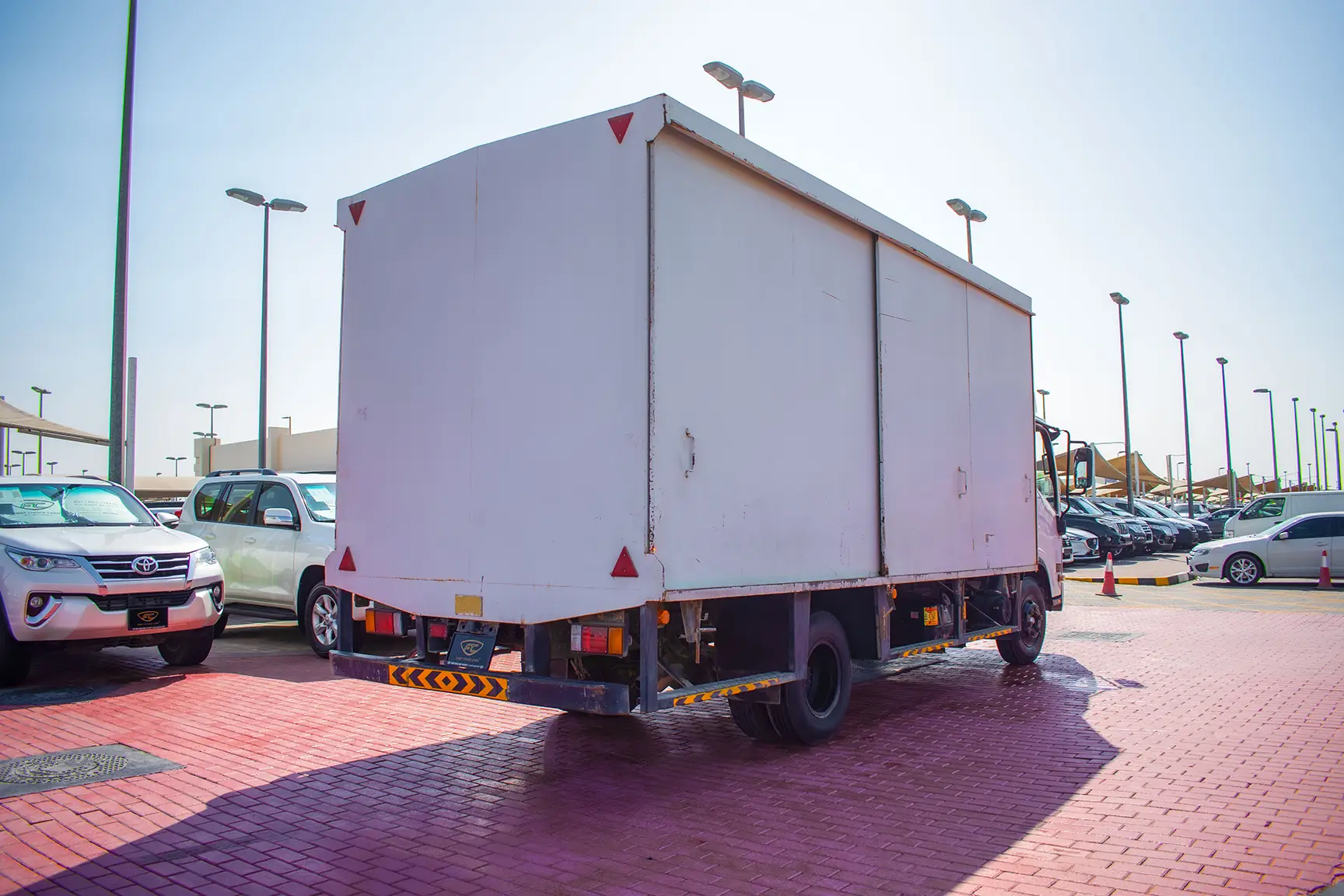 Used 2019 Isuzu NPR Cargo Box in White – Right Back Diagonal (45°) View for Sale at First Choice Cars Dubai Sharjah