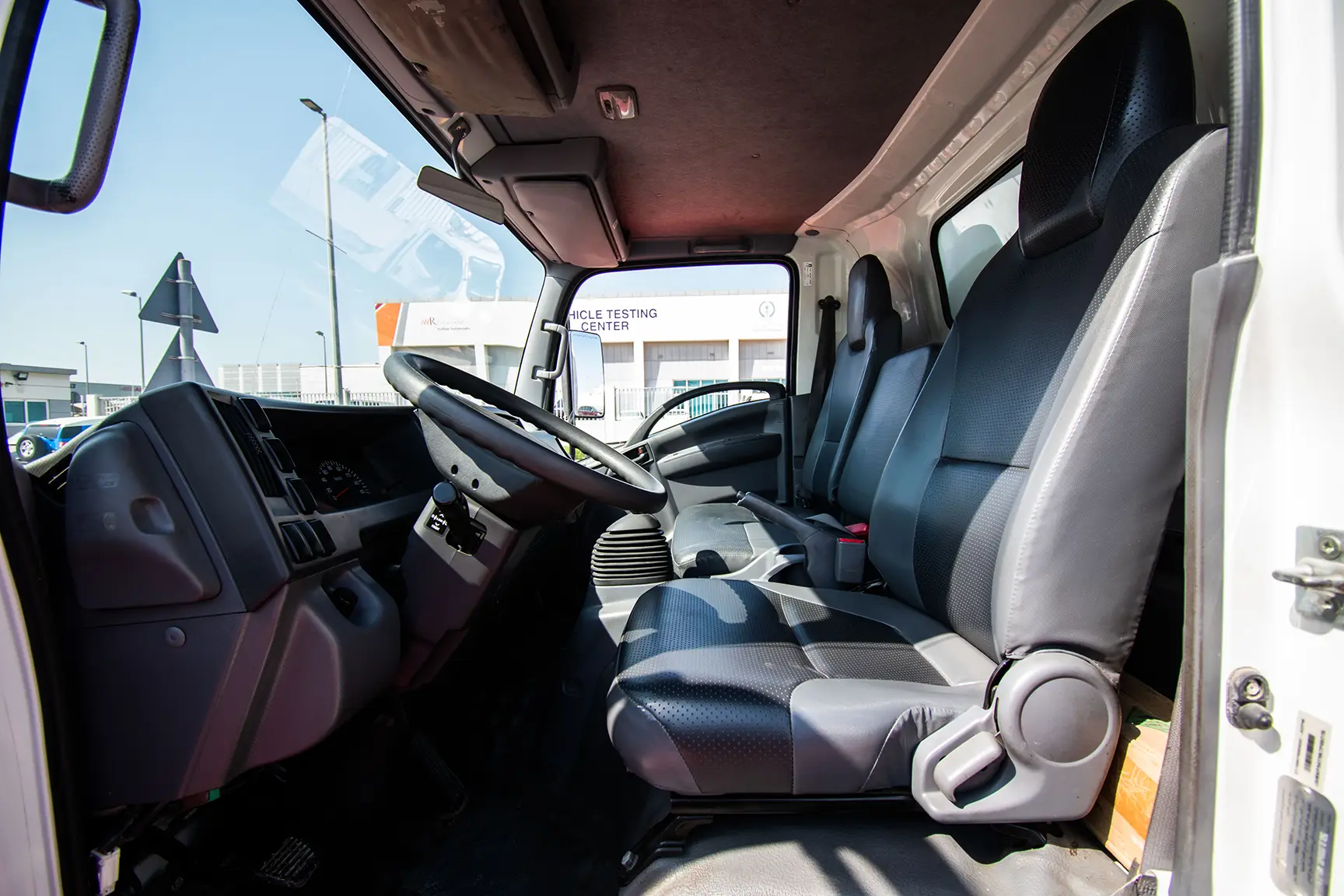 Used 2019 Isuzu NPR Cargo Box in White – Front Driver Side Cabin View for Sale at First Choice Cars Dubai Sharjah