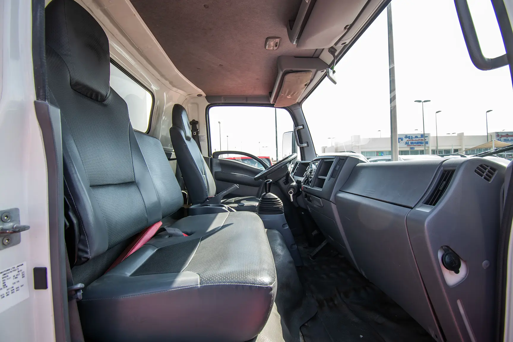 Used 2019 Isuzu NPR Cargo Box in White – Front Passenger Side Cabin View for Sale at First Choice Cars Dubai Sharjah
