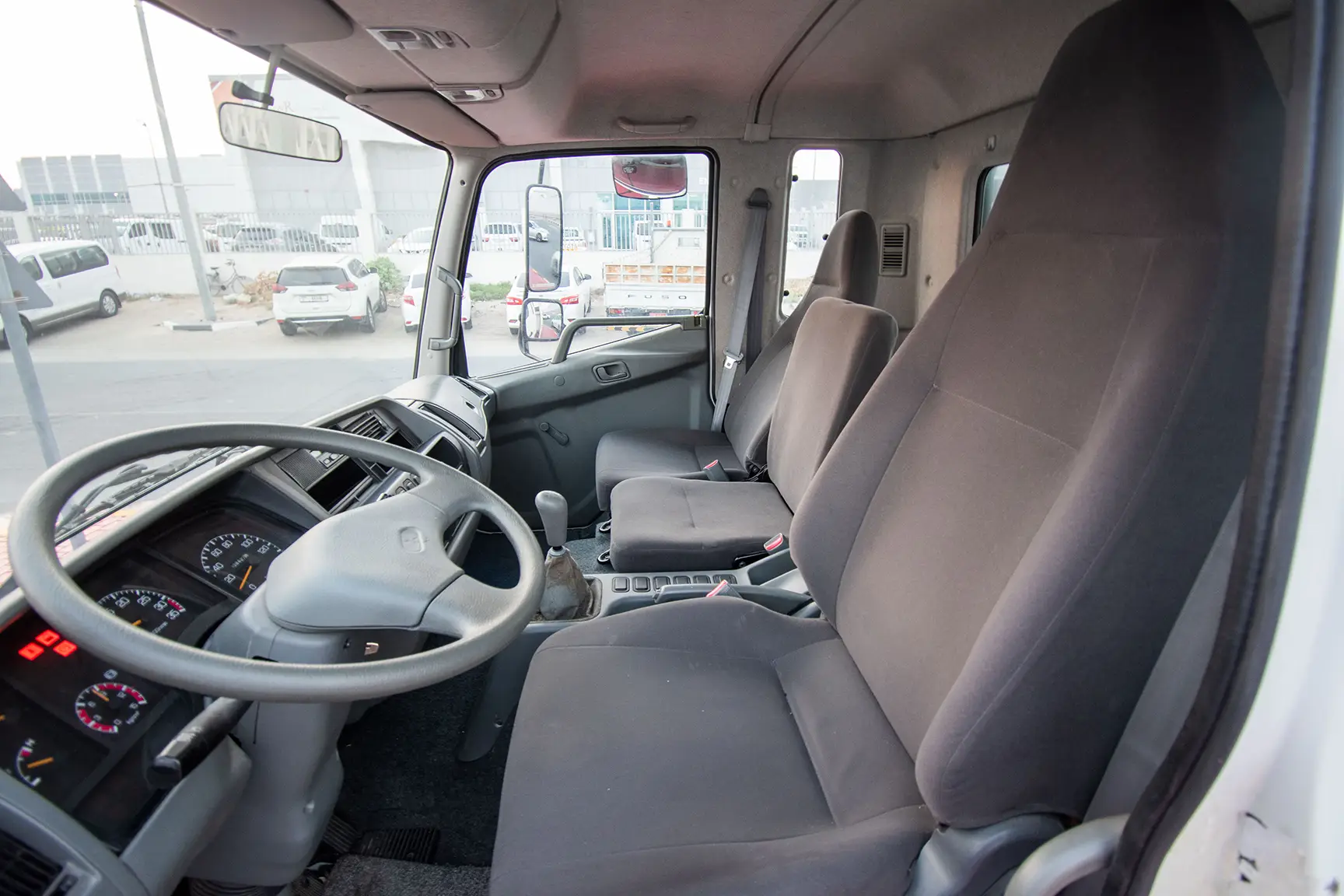 Used 2016 Mitsubishi Canter Cargo Body in White – Driver Side Dashboard & Steering View for Sale at First Choice Cars Dubai Sharjah