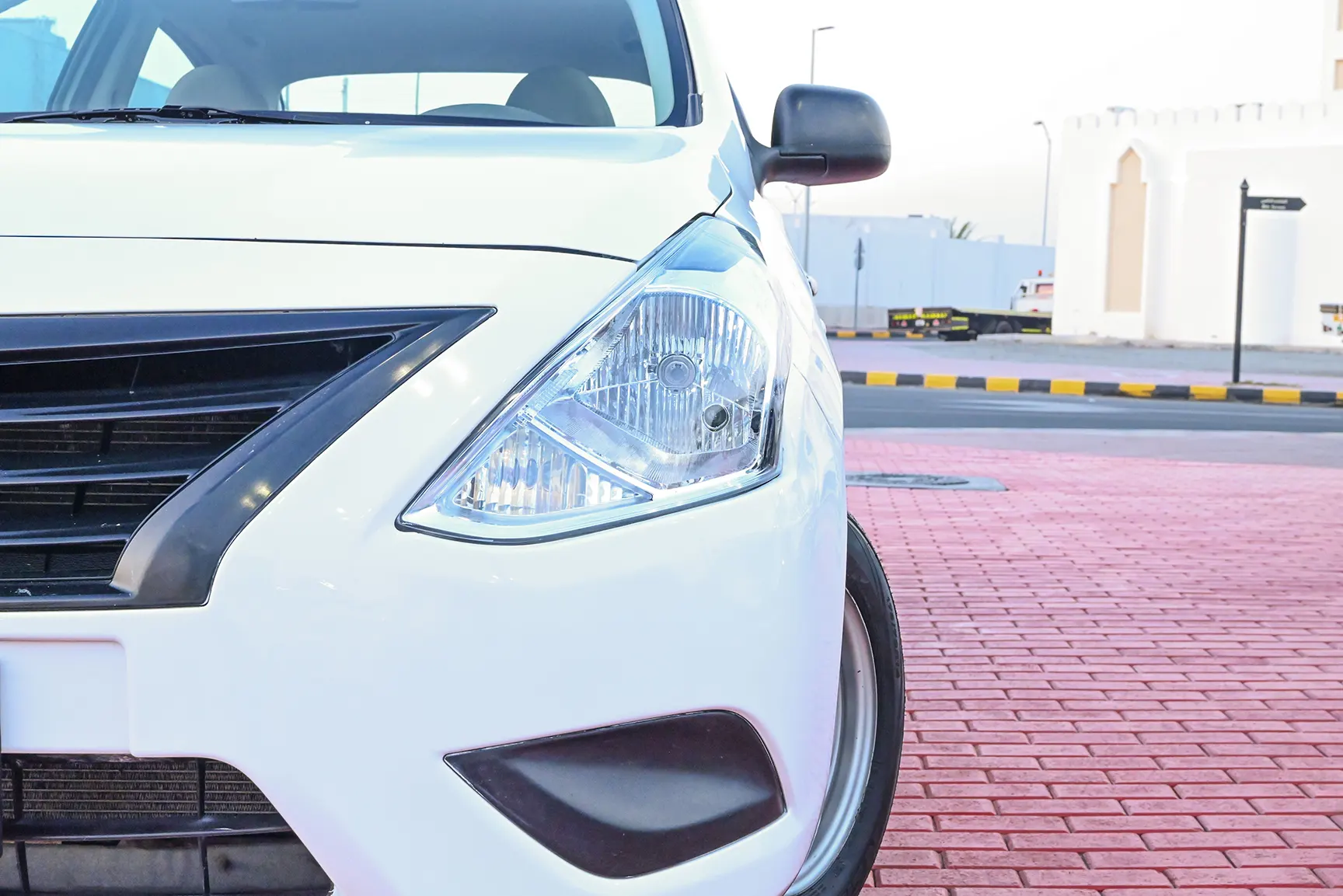 Used 2017 Nissan Sunny S White – Headlight Close-up at First Choice Cars Sharjah