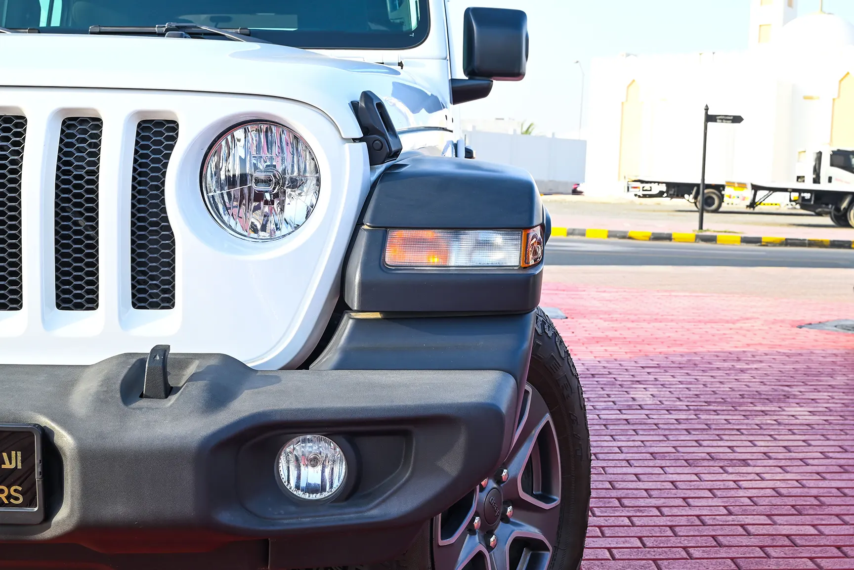 Used 2019 Jeep Wrangler Unlimited Sport White – Headlight Close-up at First Choice Cars Sharjah