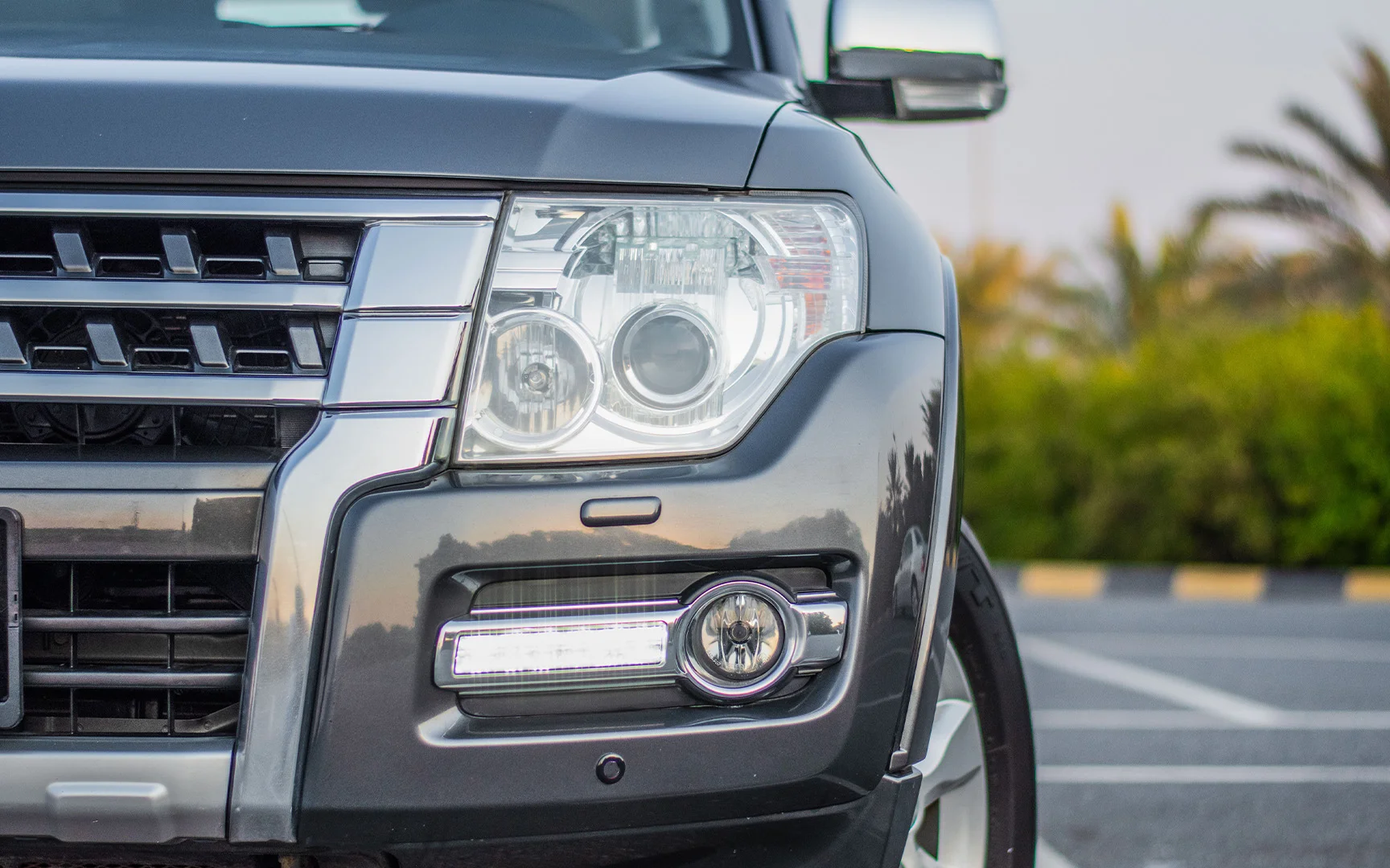 Used 2015 Mitsubishi PAJERO GLS Grey – Headlight Close-up at First Choice Cars Sharjah