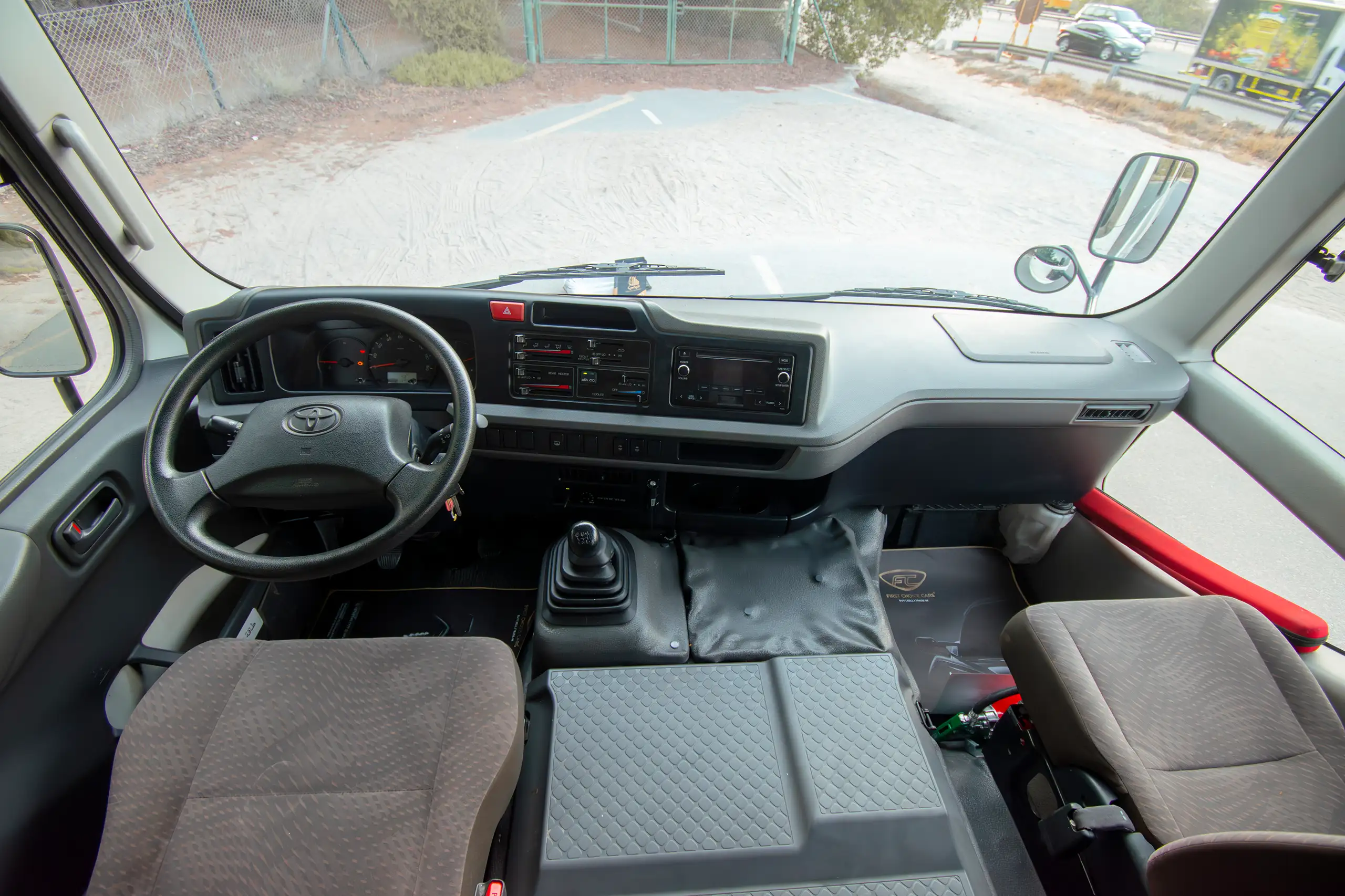 Used 2020 Toyota Coaster High Roof in White – Front Cabin / Dashboard Full View for Sale at First Choice Cars Dubai Sharjah