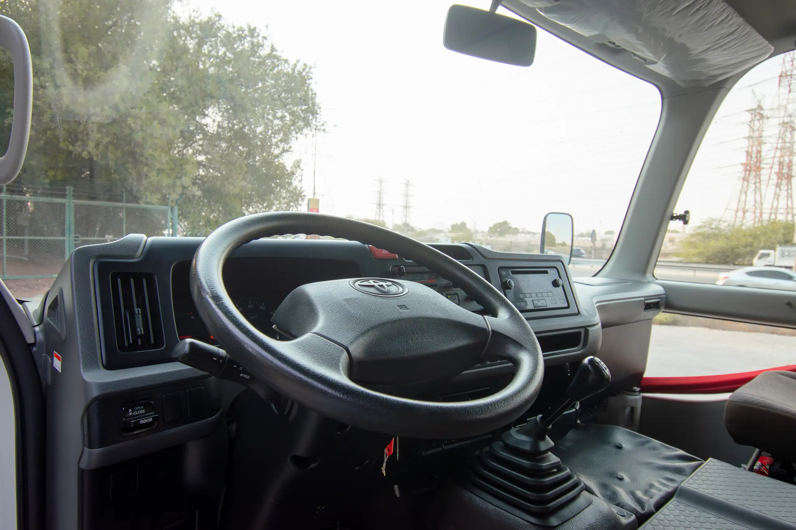 Used 2020 Toyota Coaster High Roof in White – Driver Side Dashboard & Steering View for Sale at First Choice Cars Dubai Sharjah