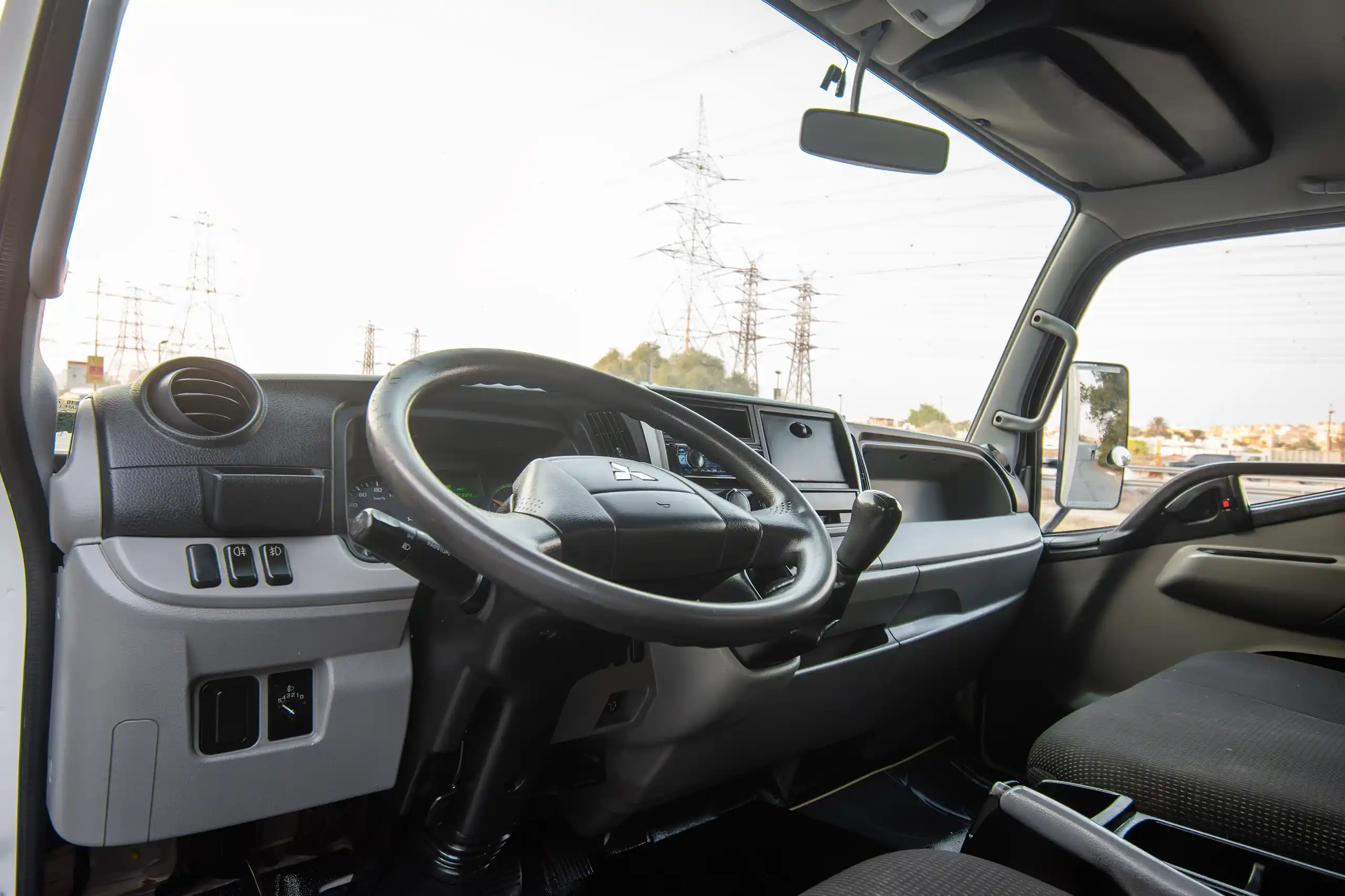 Used 2020 Mitsubishi Canter Cargo Box in White – Driver Side Dashboard & Steering View for Sale at First Choice Cars Dubai Sharjah
