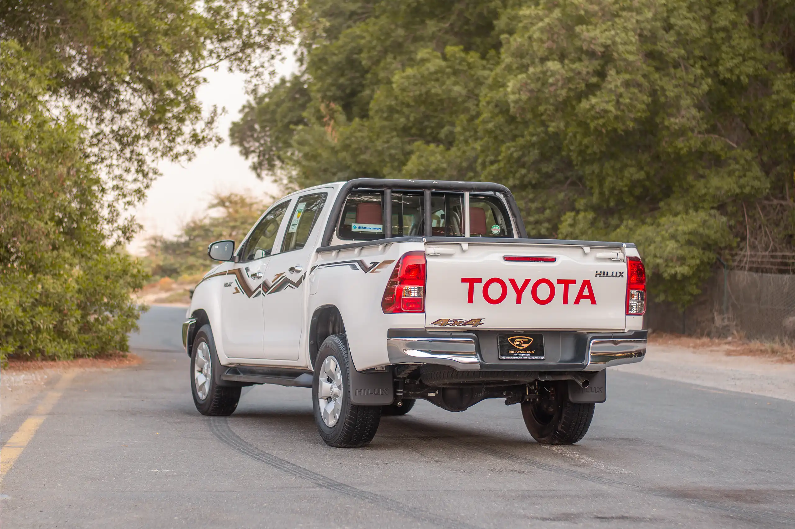 Used 2024 Toyota Hilux DLX Double Cabin in White – Left Back Diagonal (45°) View for Sale at First Choice Cars Dubai Sharjah