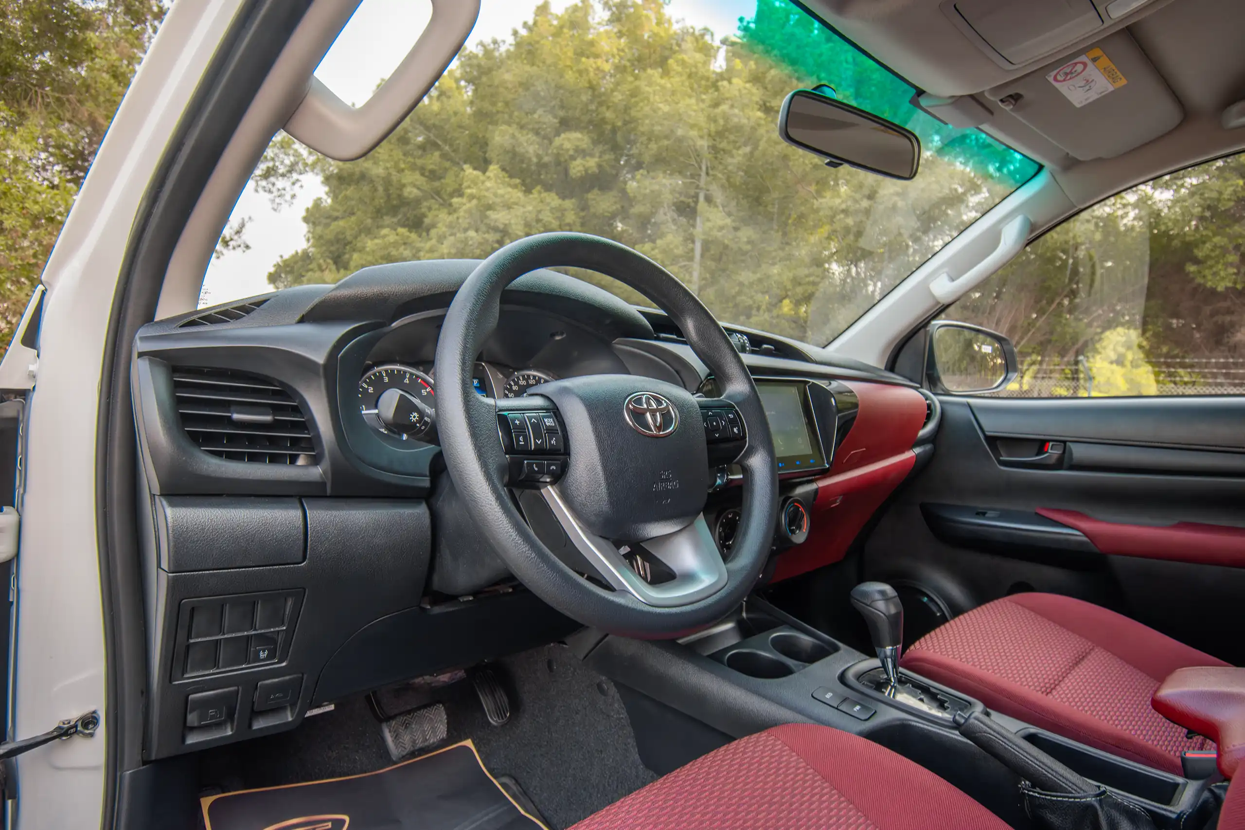 Used 2024 Toyota Hilux DLX Double Cabin in White – Driver Side Dashboard & Steering View for Sale at First Choice Cars Dubai Sharjah