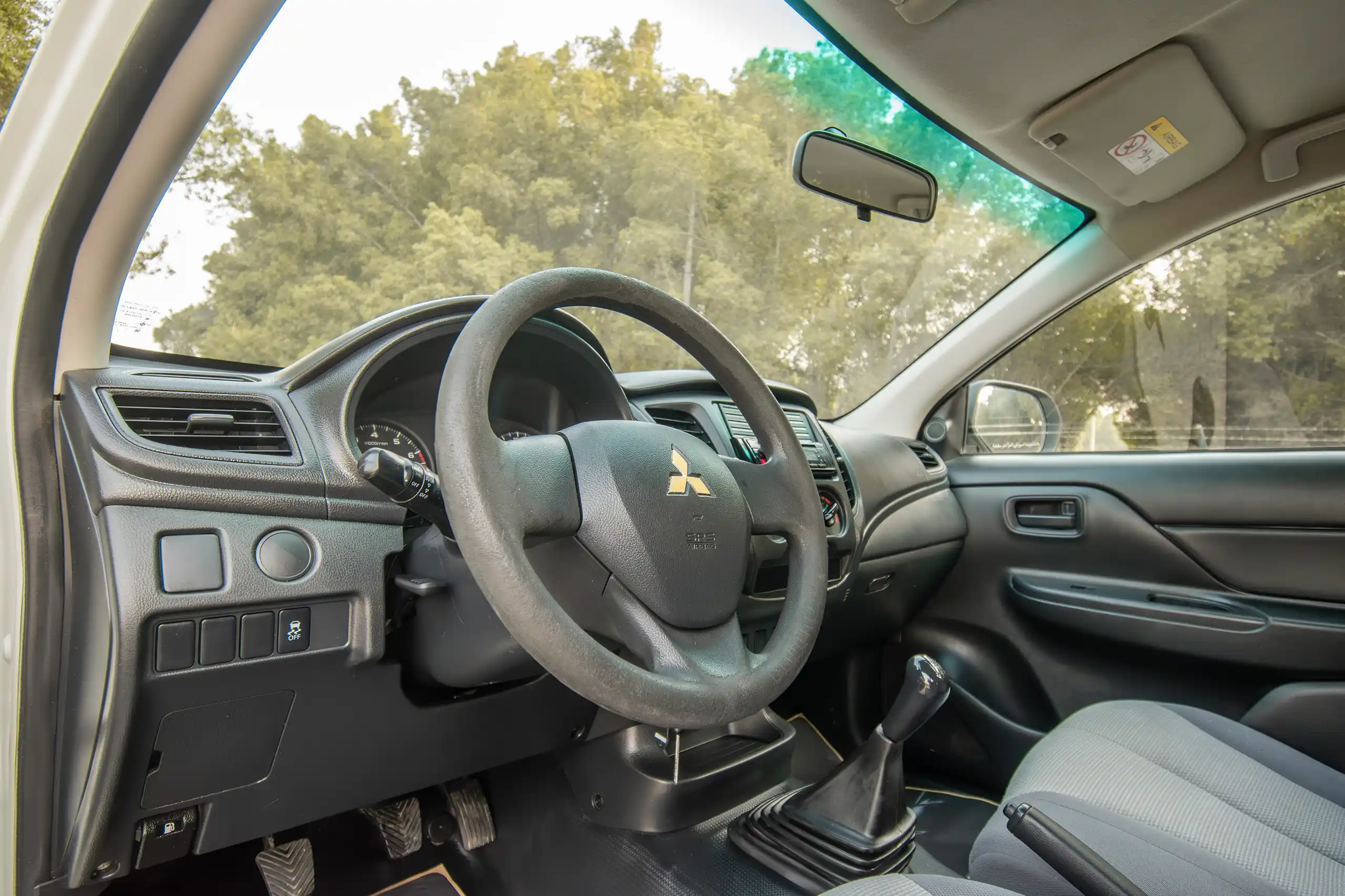 Used 2023 Mitsubishi L200 GL Double Cabin White – Driver Side Dashboard & Steering View at First Choice Cars Sharjah