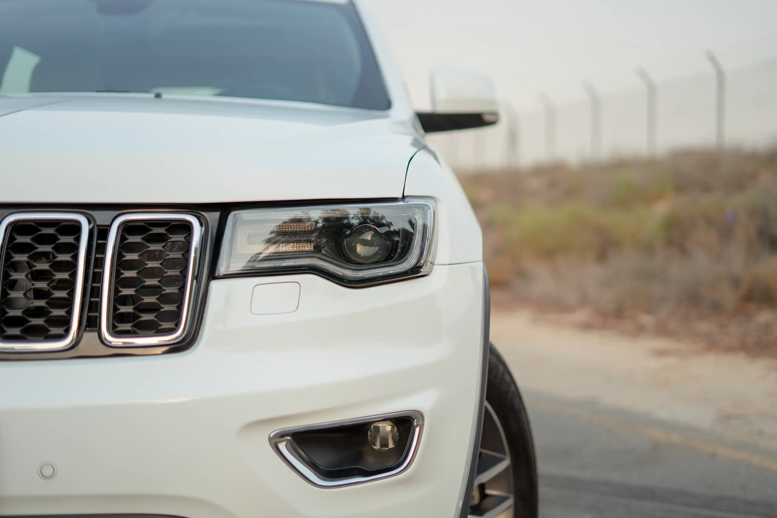 Used 2021 Jeep Grand Cherokee Limited White – Headlight Close-up at First Choice Cars Sharjah