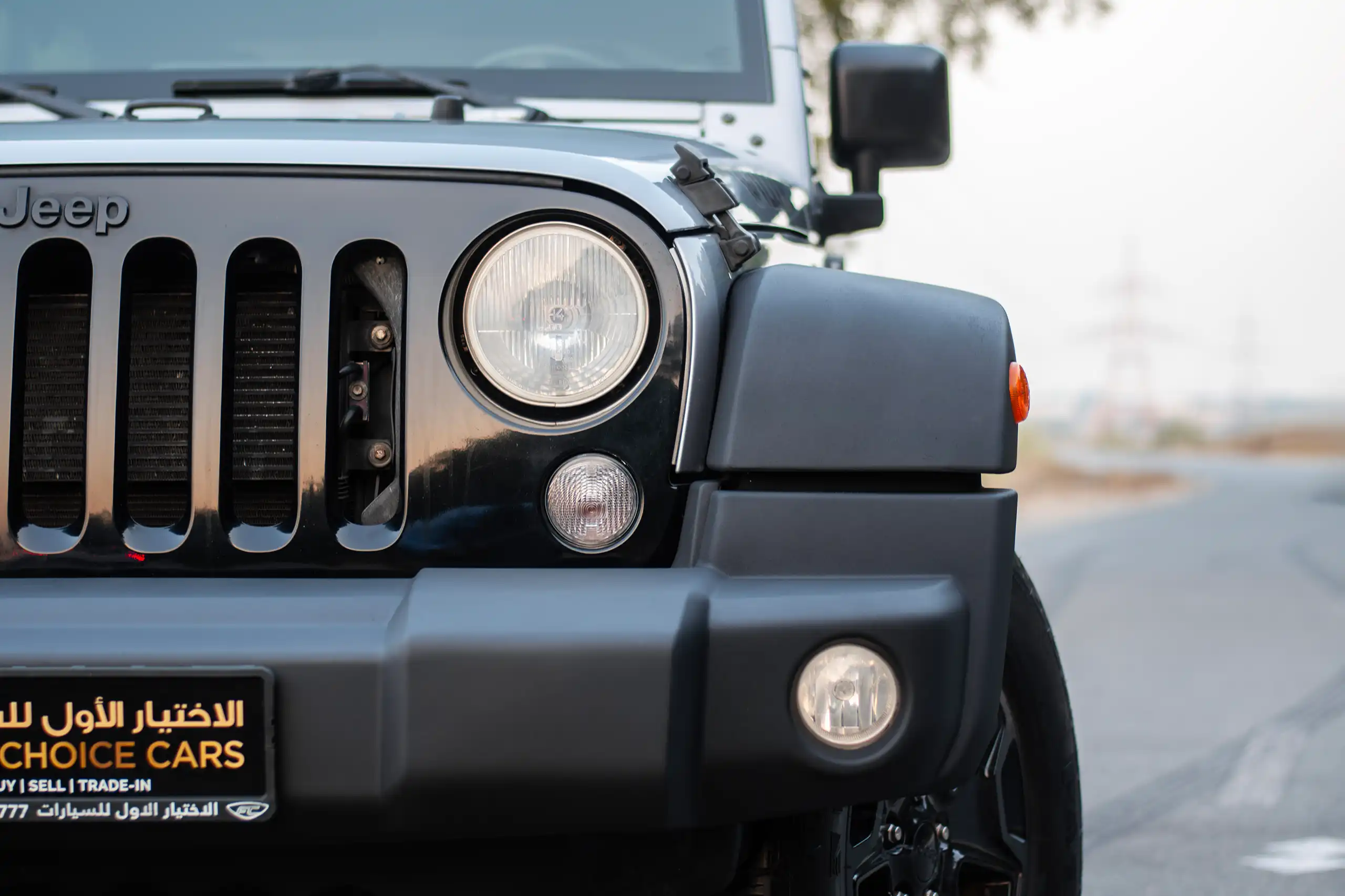 Used 2018 Jeep Wrangler Unlimited Willys Wheeler in Silver – Headlight Close-up for Sale at First Choice Cars Dubai Sharjah