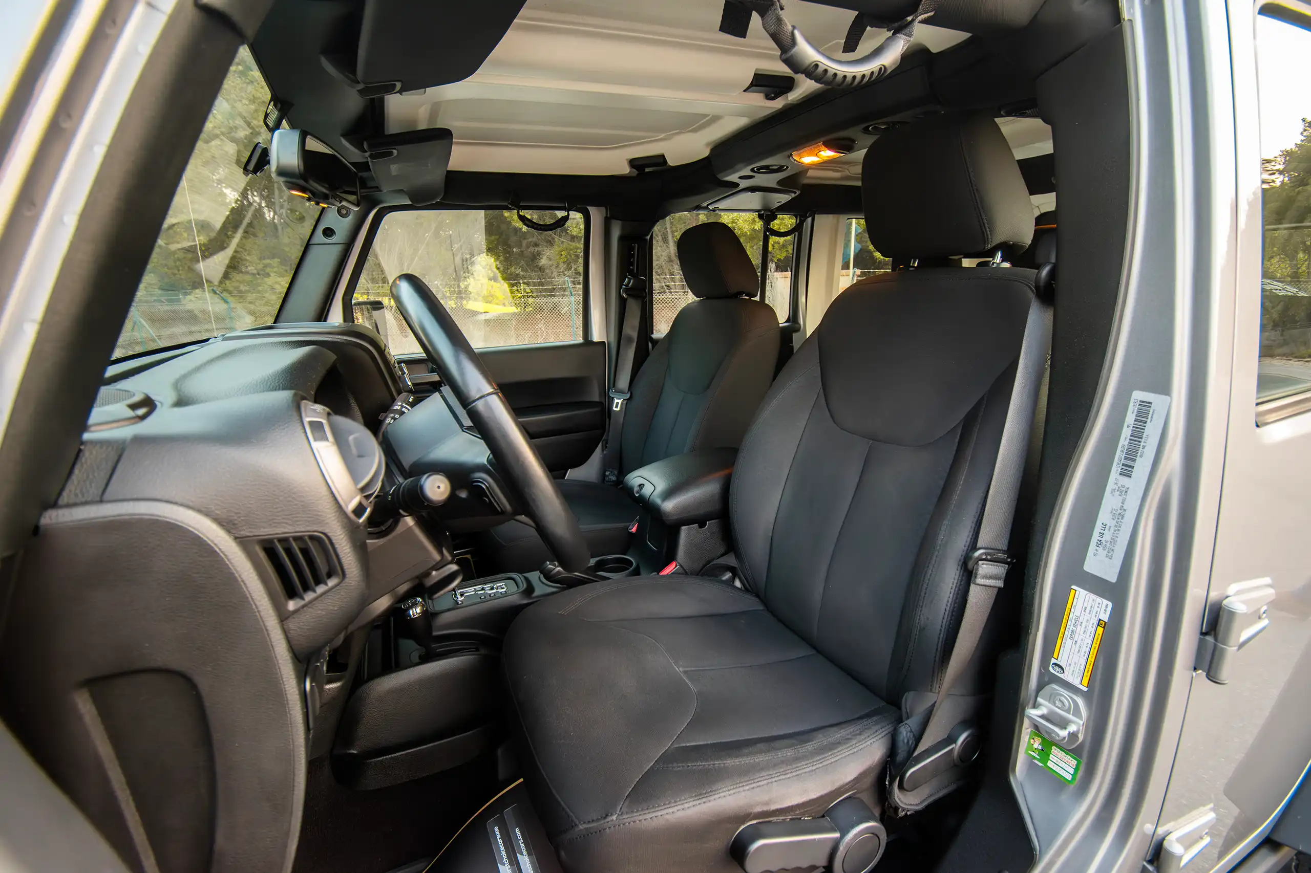 Used 2018 Jeep Wrangler Unlimited Willys Wheeler in Silver – Front Driver Side Cabin View for Sale at First Choice Cars Dubai Sharjah