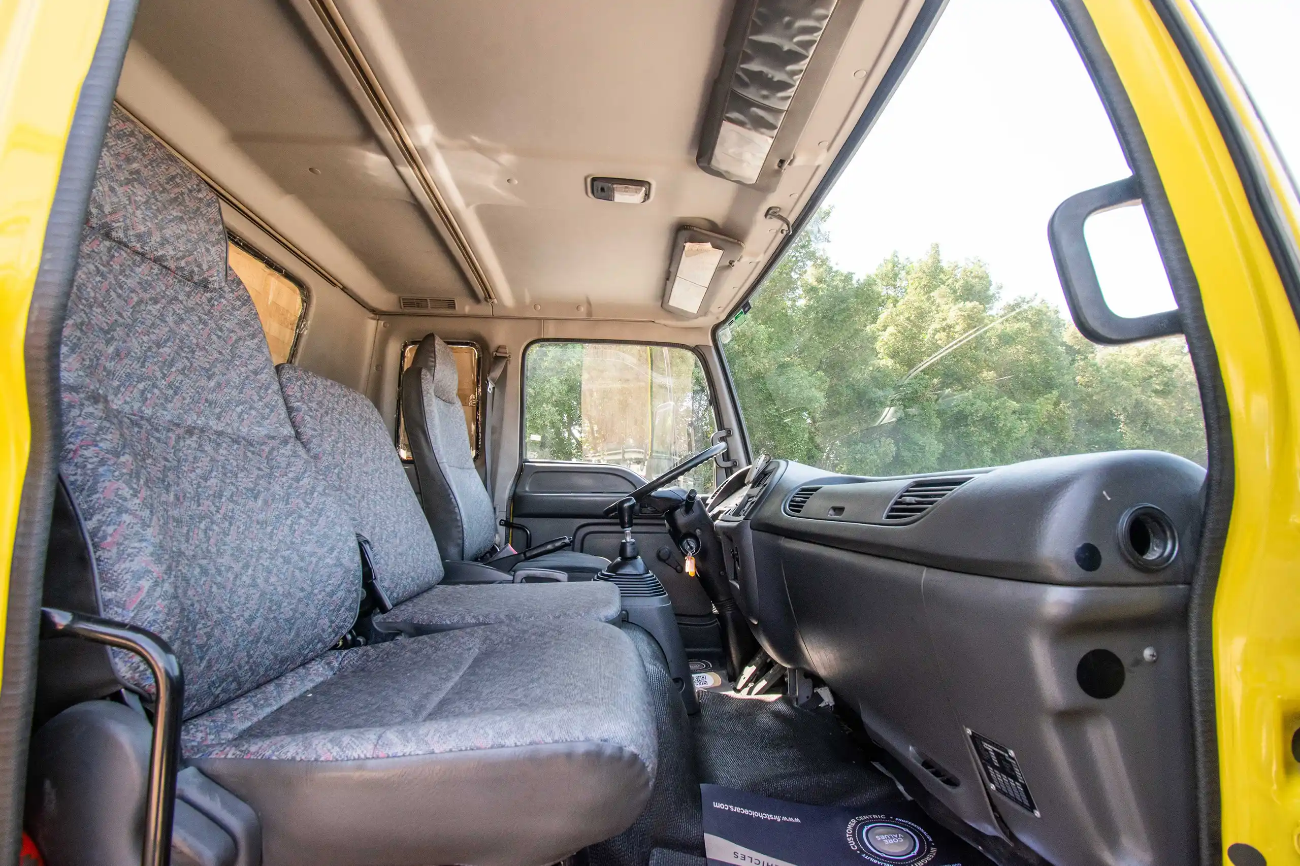 Used 2016 Isuzu FSR Cargo Body in Yellow – Front Passenger Side Cabin View for Sale at First Choice Cars Dubai Sharjah