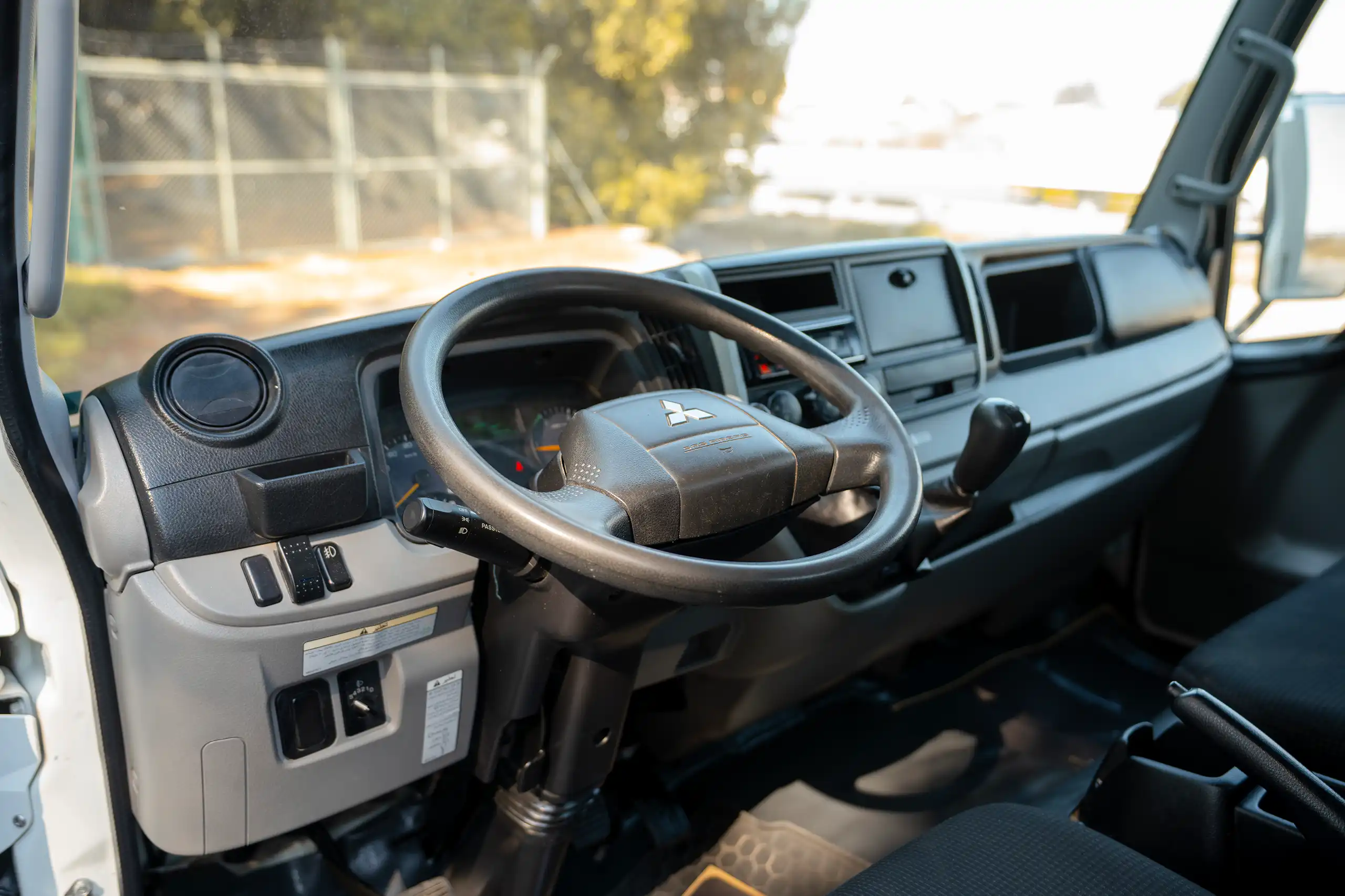 Used 2022 Mitsubishi Canter Cargo Body in White – Driver Side Dashboard & Steering View for Sale at First Choice Cars Dubai Sharjah