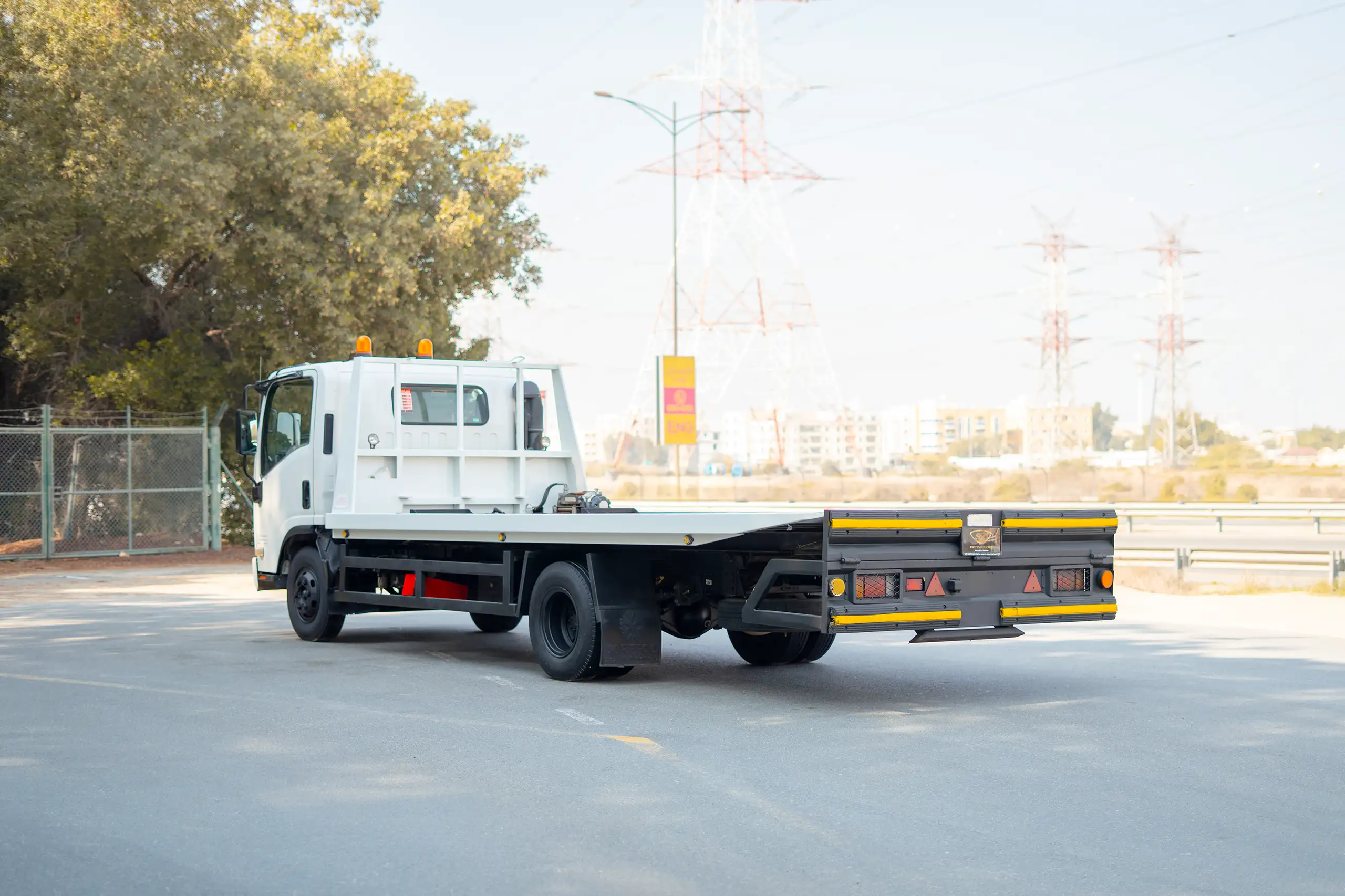Used 2017 Isuzu NPR Recovery in White – Left Back Diagonal (45°) View for Sale at First Choice Cars Dubai Sharjah