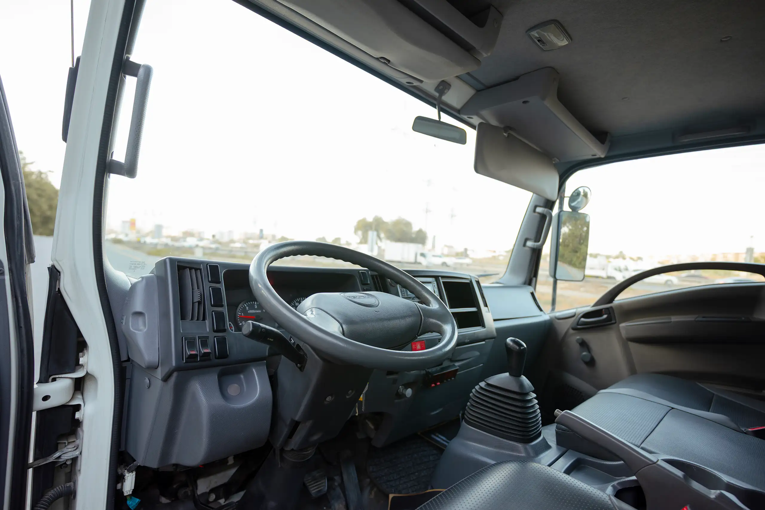 Used 2017 Isuzu NPR Recovery in White – Driver Side Dashboard & Steering View for Sale at First Choice Cars Dubai Sharjah