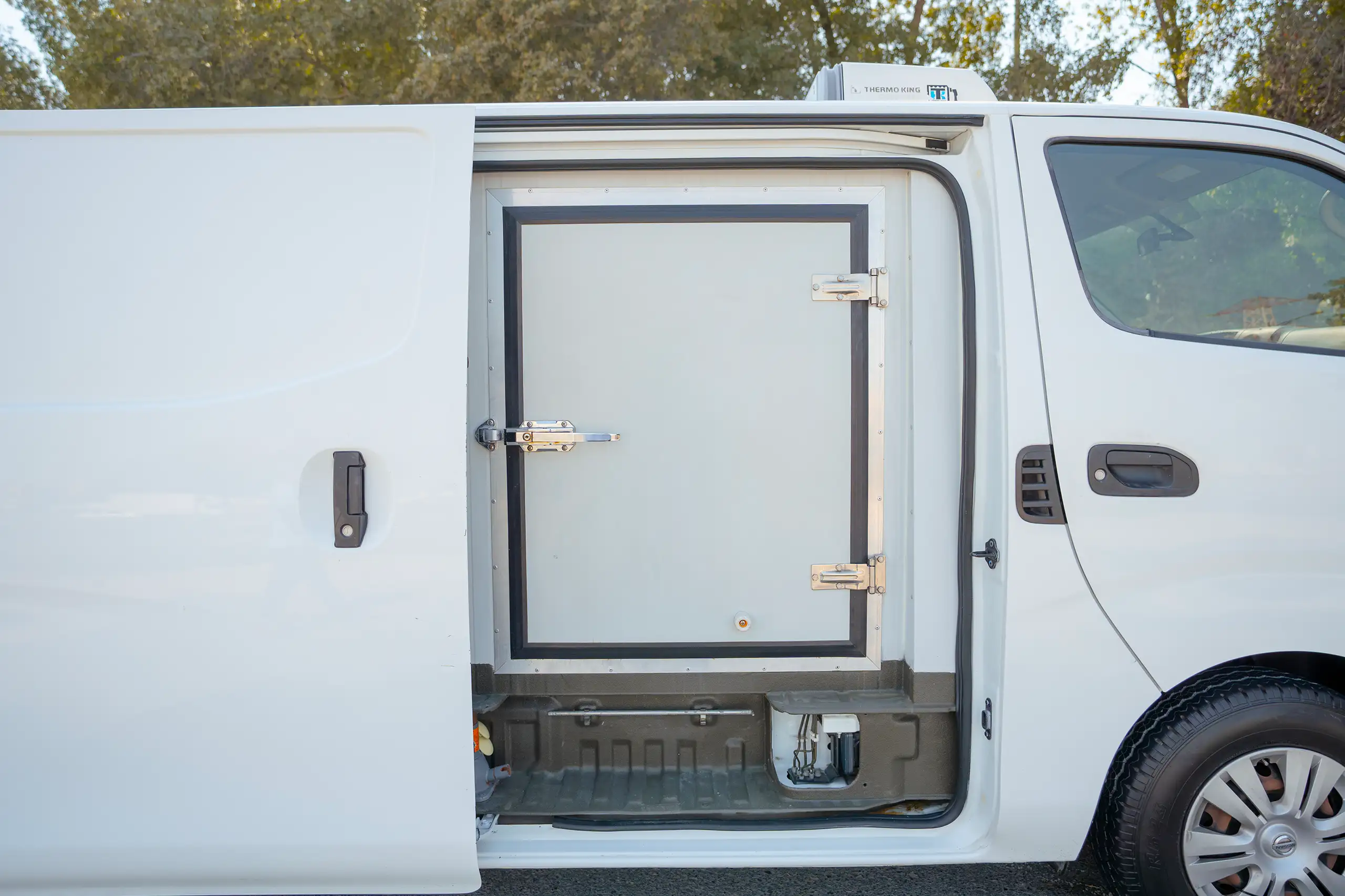 Used 2020 Nissan Urvan Standard Roof in White – Right Side – Airtight Freezer Door – Side View for Sale at First Choice Cars Dubai Sharjah