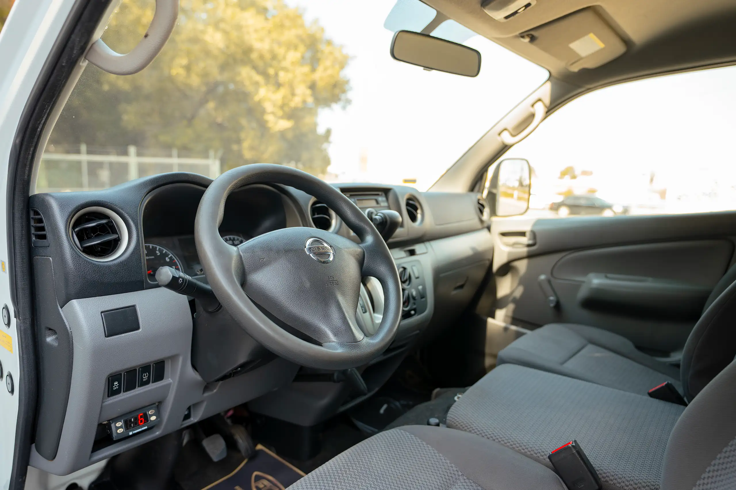 Used 2020 Nissan Urvan Standard Roof in White – Driver Side Dashboard & Steering View for Sale at First Choice Cars Dubai Sharjah