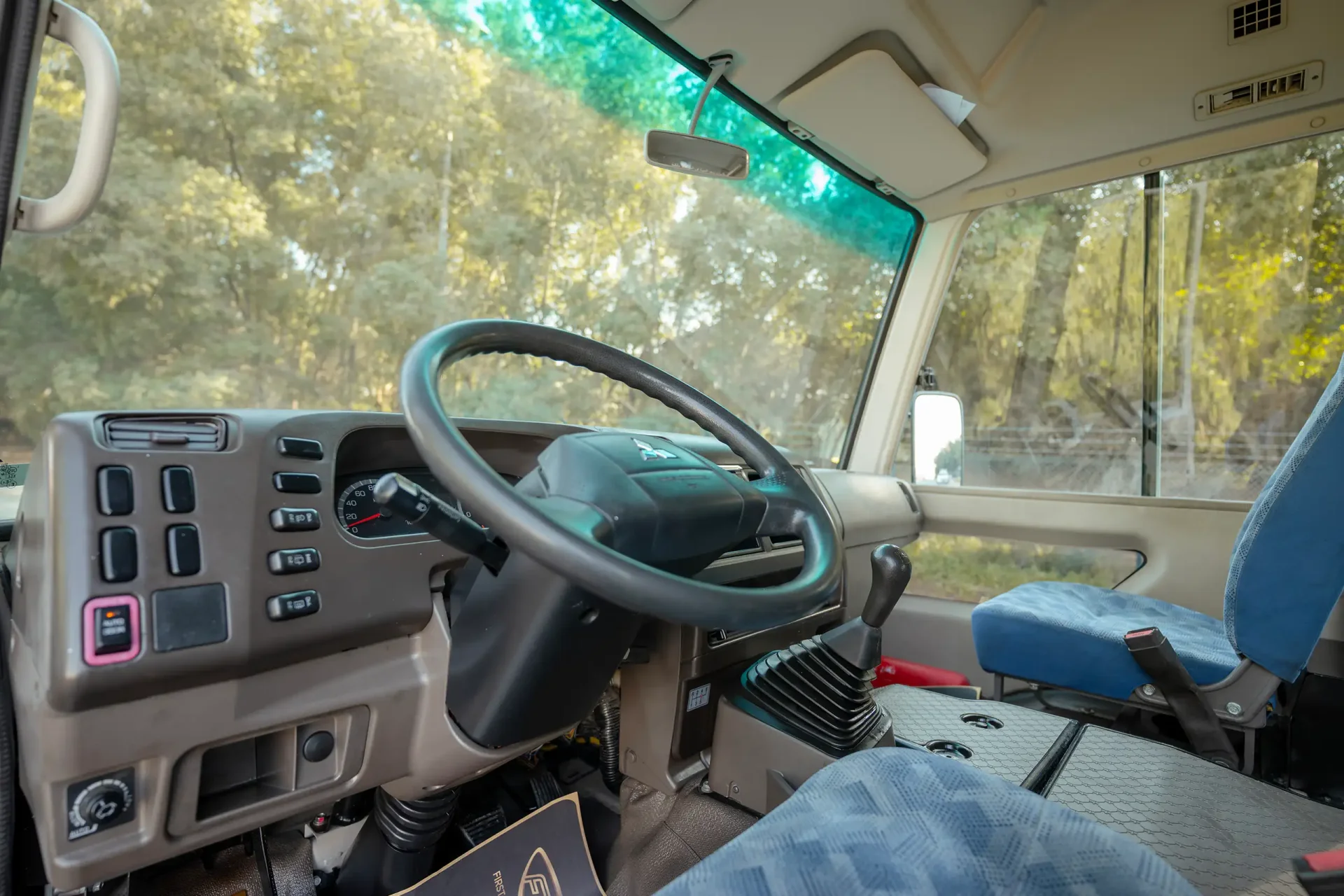 Used 2022 Mitsubishi ROSA Passenger Bus in White – Driver Side Dashboard & Steering View for Sale at First Choice Cars Dubai Sharjah