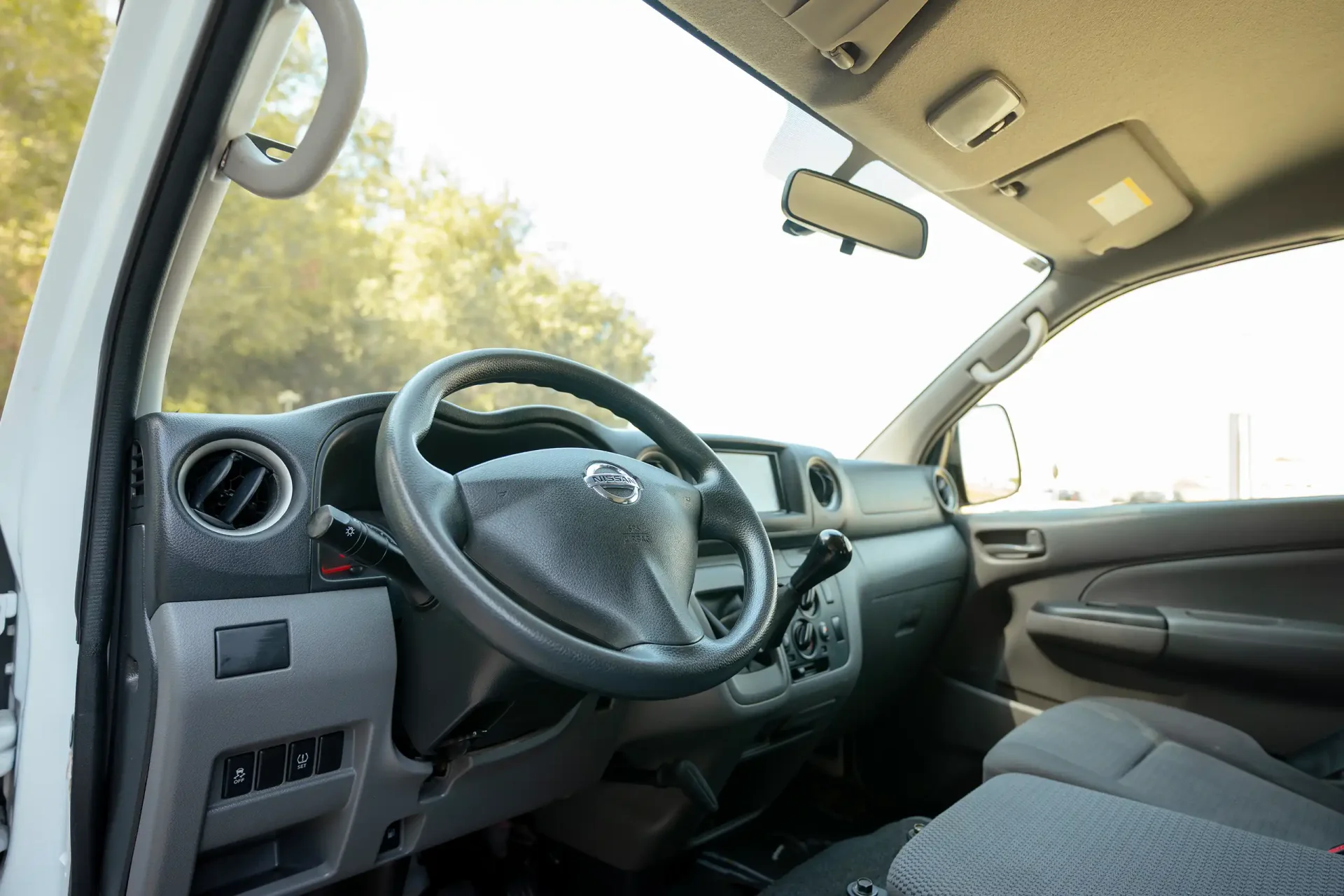 Used 2022 Nissan Urvan Standard Roof in White – Driver Side Dashboard & Steering View for Sale at First Choice Cars Dubai Sharjah