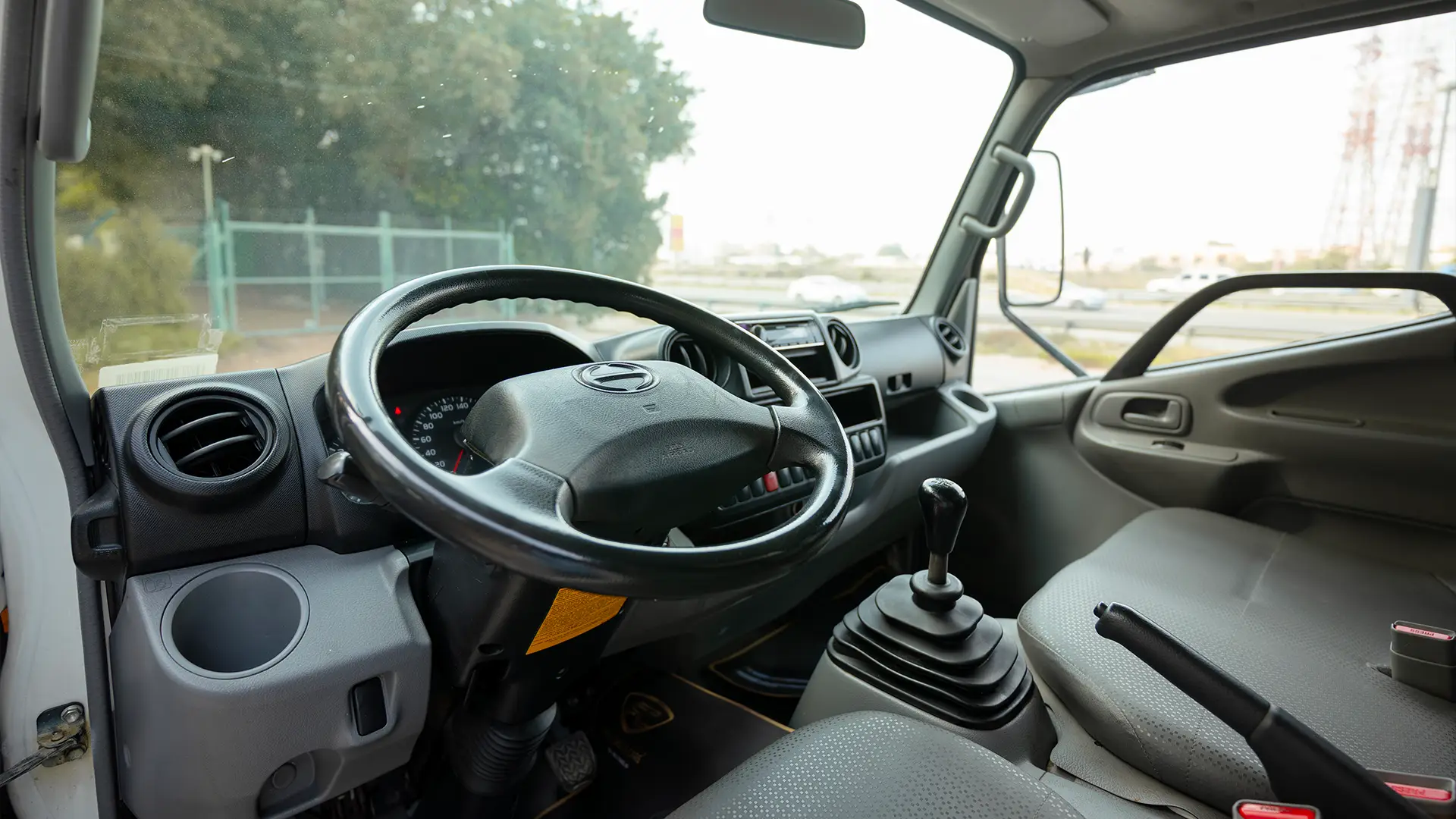 Used 2019 Hino 300 Dry Box in White – Driver Side Dashboard & Steering View for Sale at First Choice Cars Dubai Sharjah