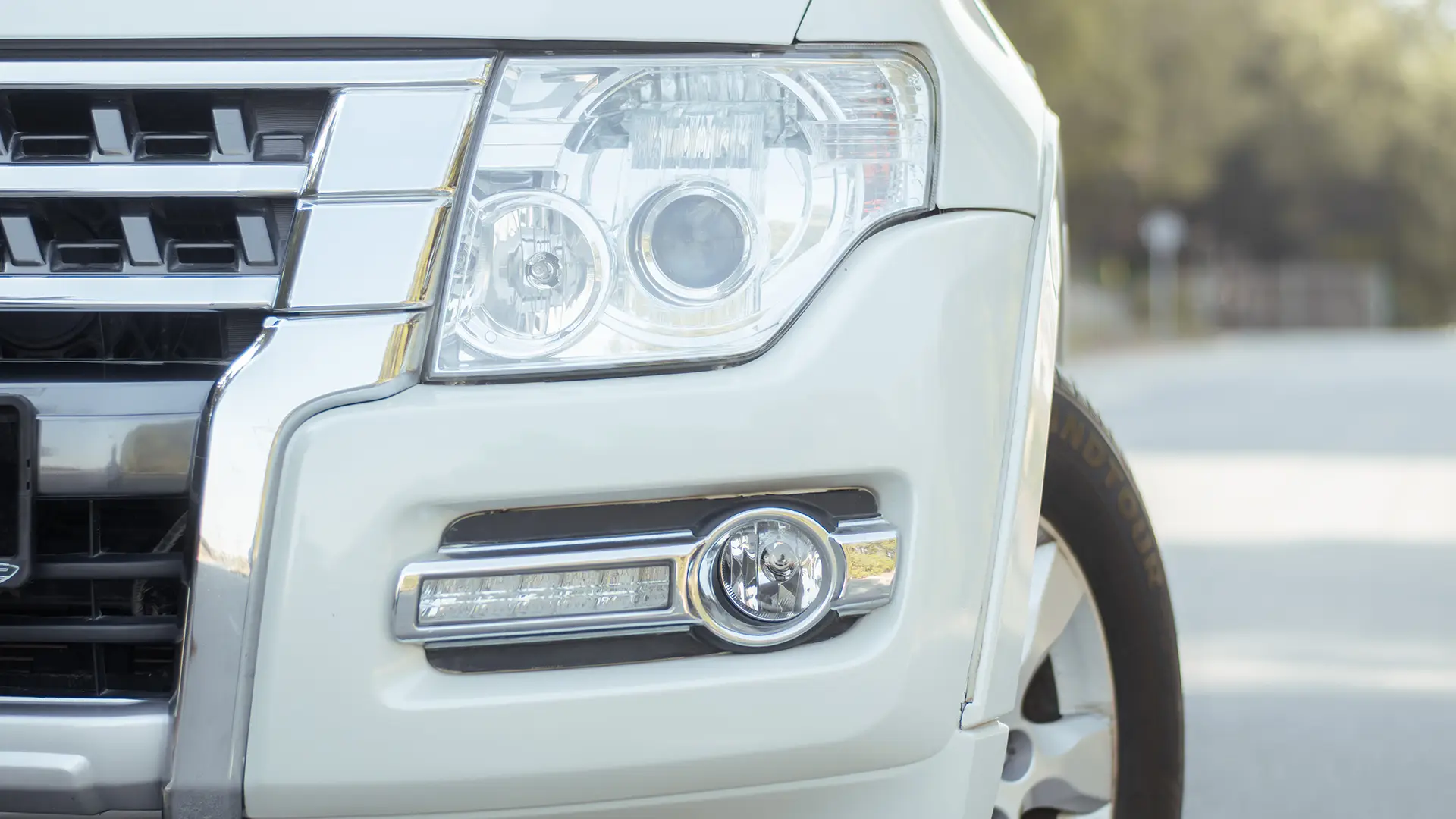 Used 2022 Mitsubishi Pajero GLS in White – Headlight Close-up for Sale at First Choice Cars Dubai Sharjah