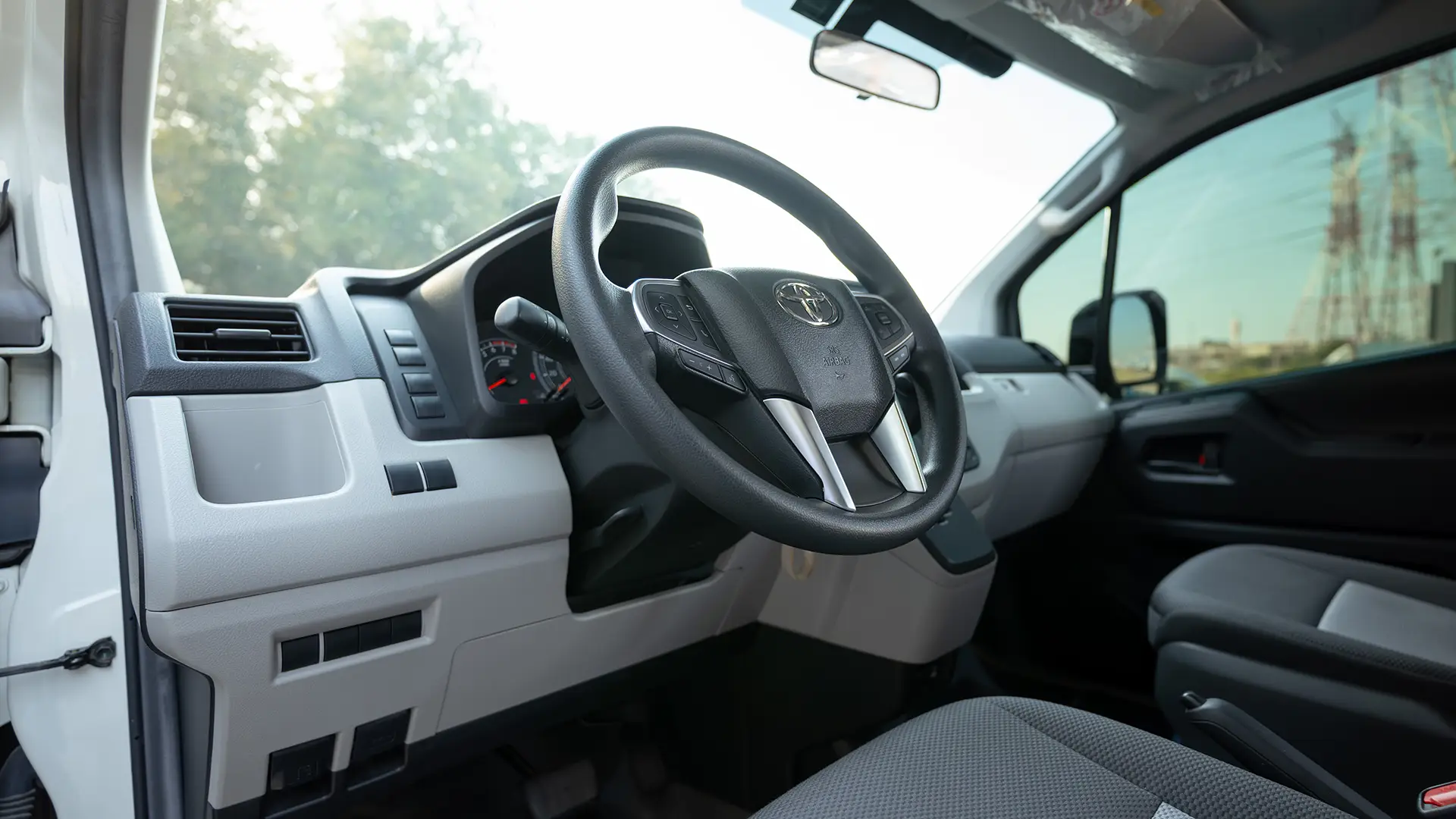 Used 2025 Toyota Hiace GLX High Roof in White – Driver Side Dashboard & Steering View for Sale at First Choice Cars Dubai Sharjah