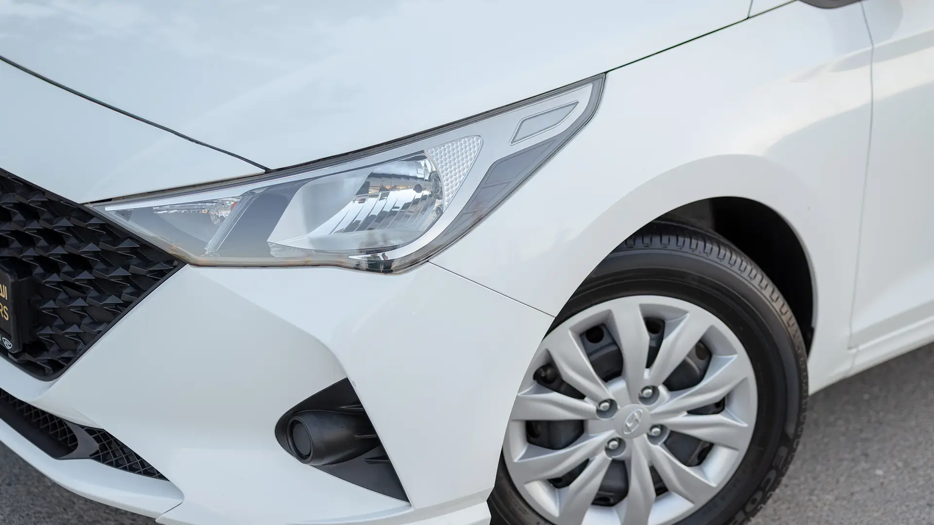Used 2023 Hyundai Accent Smart in White – Headlight Close-up for Sale at First Choice Cars Dubai Sharjah