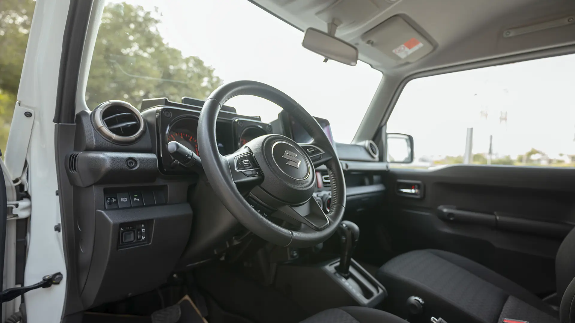 Used 2024 Suzuki Jimny GLX in White – Driver Side Dashboard & Steering View for Sale at First Choice Cars Dubai Sharjah