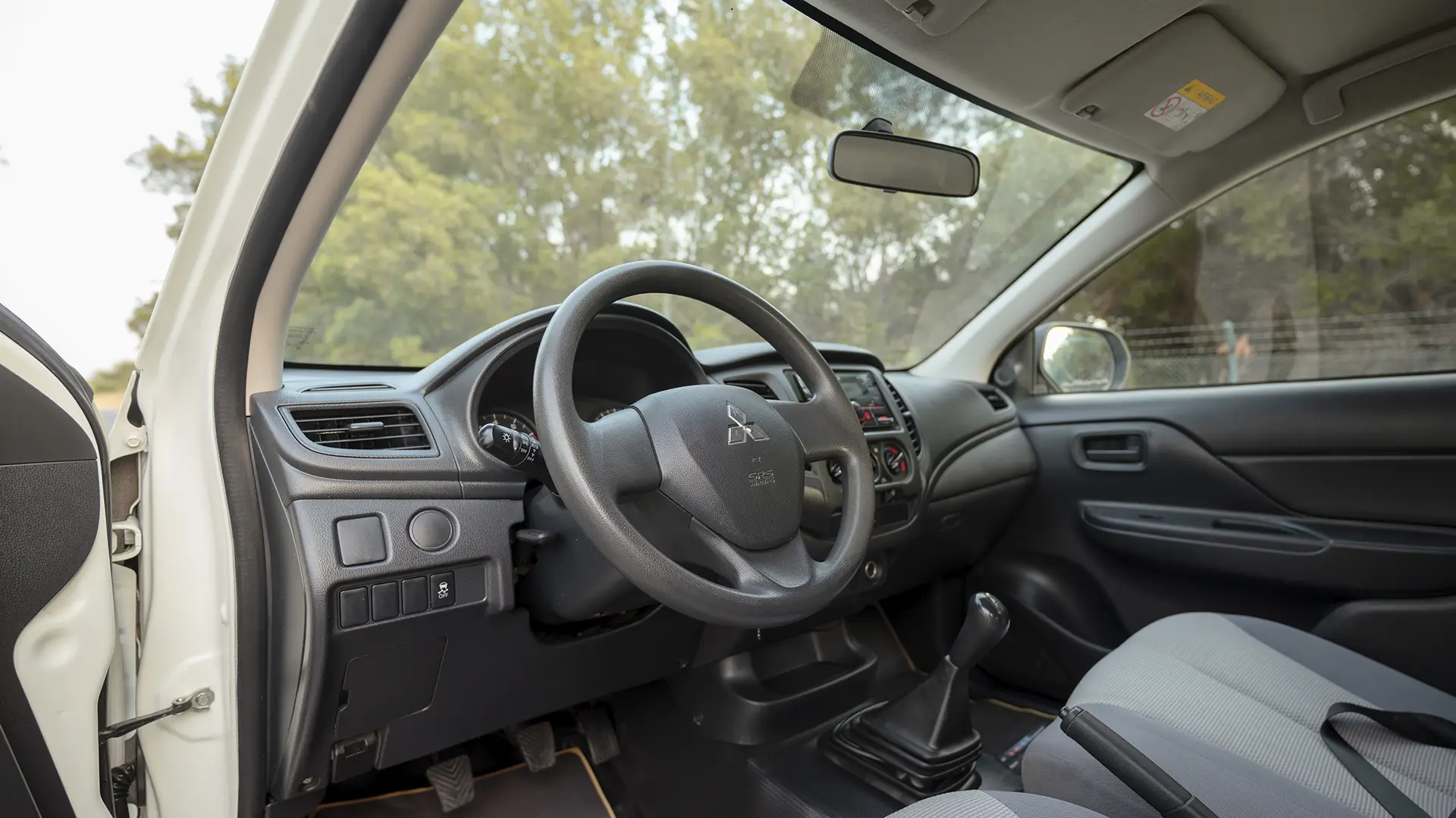Used 2023 Mitsubishi L200 GLX Double Cabin in White – Driver Side Dashboard & Steering View for Sale at First Choice Cars Dubai Sharjah