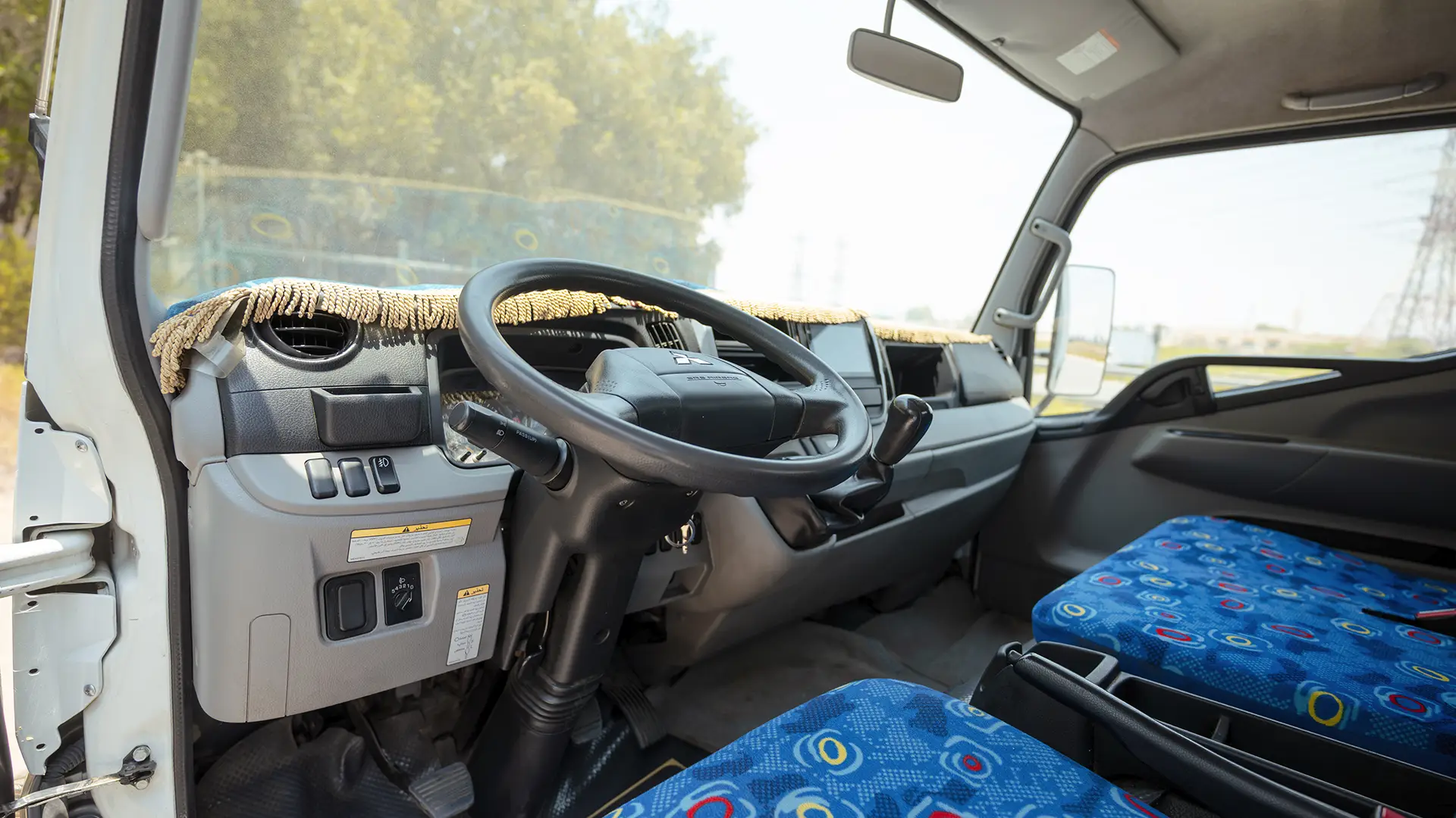 Used 2024 Mitsubishi Canter Cargo Body in White – Driver Side Dashboard & Steering View for Sale at First Choice Cars Dubai Sharjah