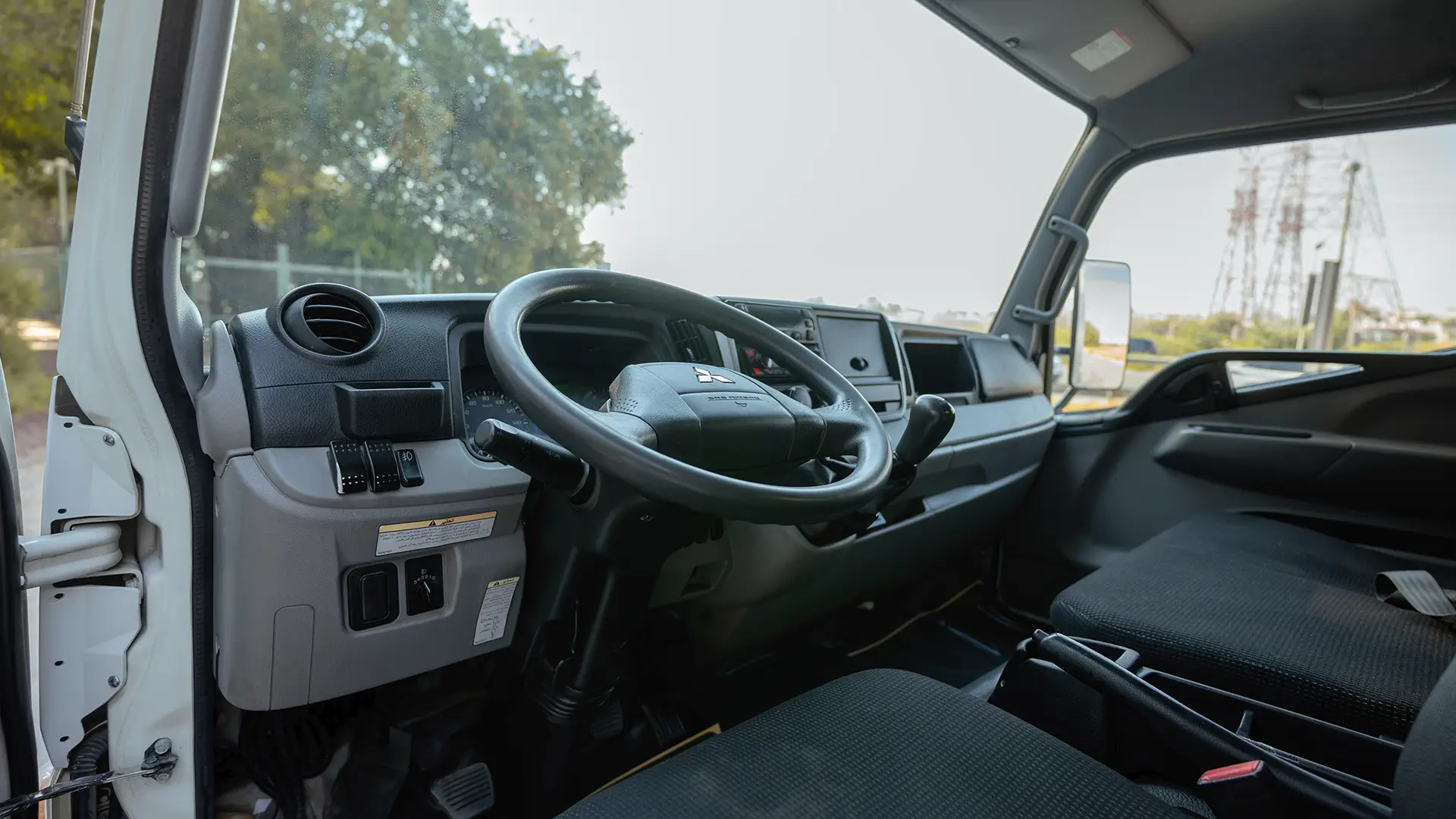 Used 2022 Mitsubishi Canter Chiller Box in White – Driver Side Dashboard & Steering View for Sale at First Choice Cars Dubai Sharjah