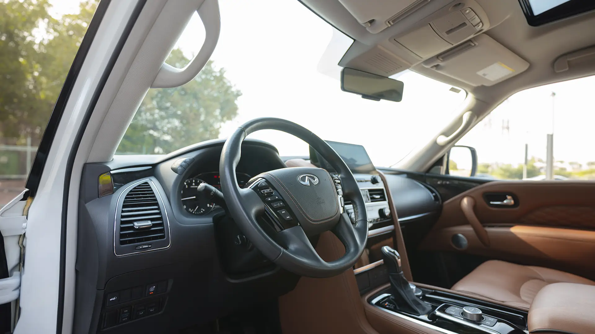 Used 2023 Infiniti QX80 Sensory in White – Driver Side Dashboard & Steering View for Sale at First Choice Cars Dubai Sharjah