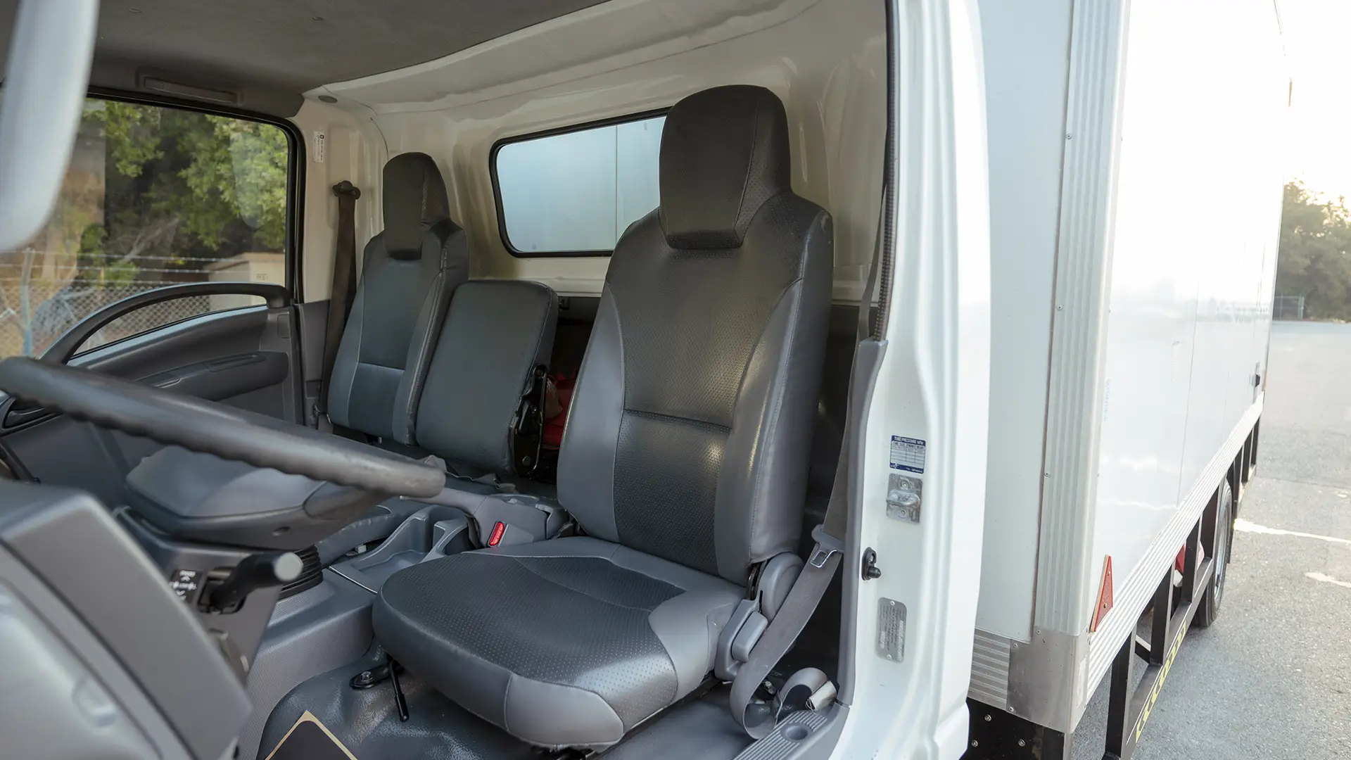Used 2023 Isuzu Reward Chiller in White – Front Driver Side Cabin View for Sale at First Choice Cars Dubai Sharjah